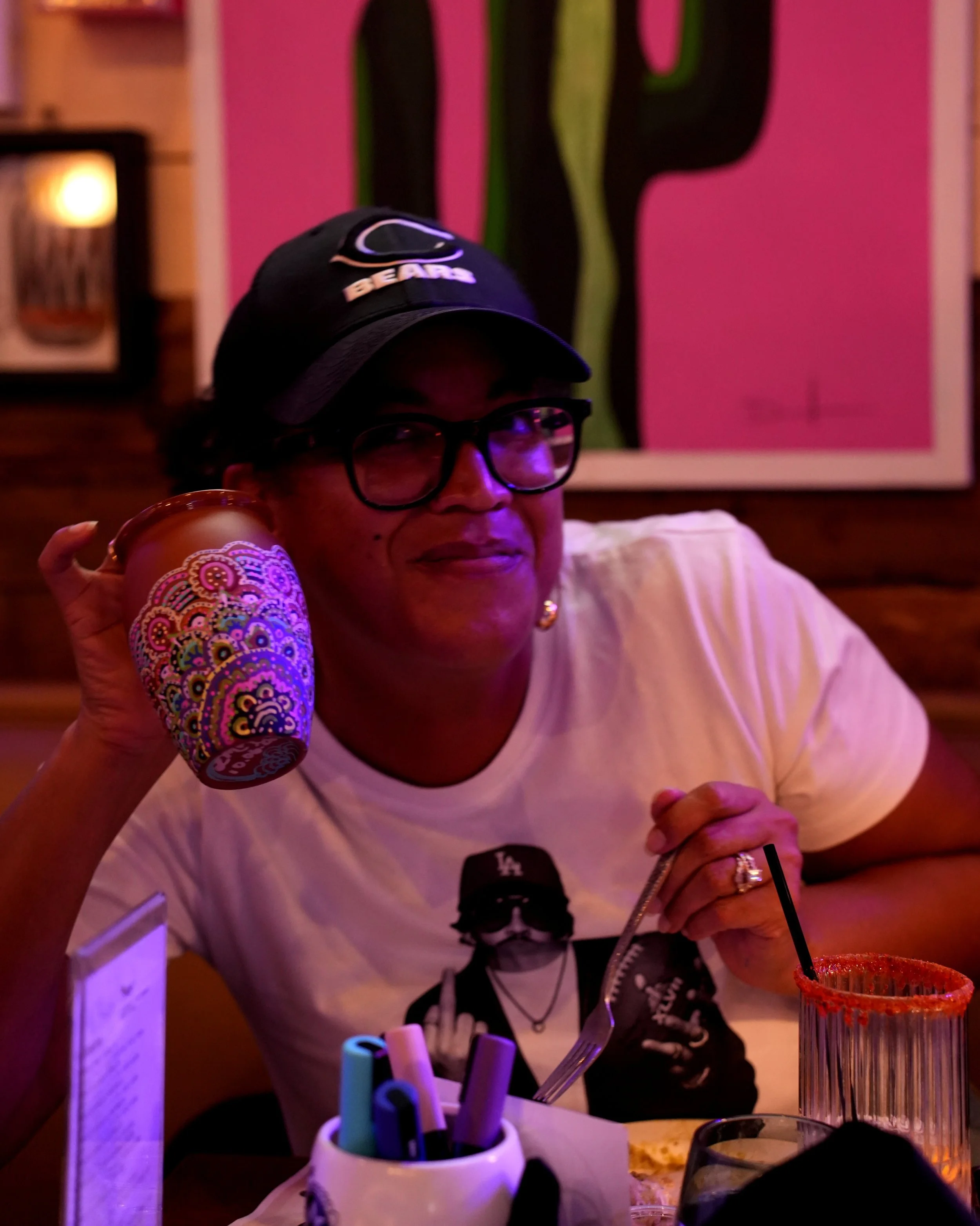 Guest holding her hand-painted cantarito cup at a Diego paint and sip