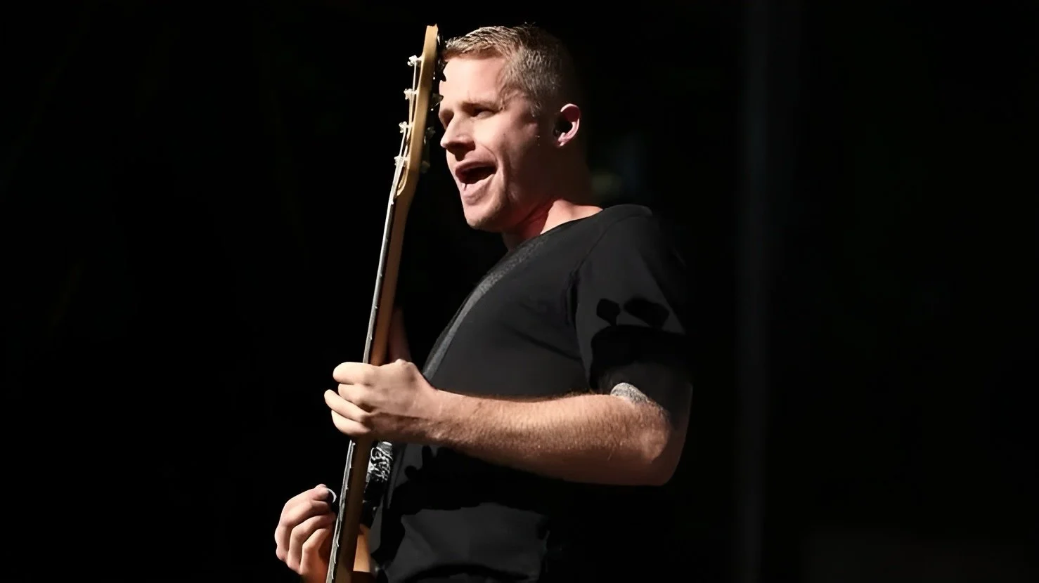 Man playing guitar on stage with dark background