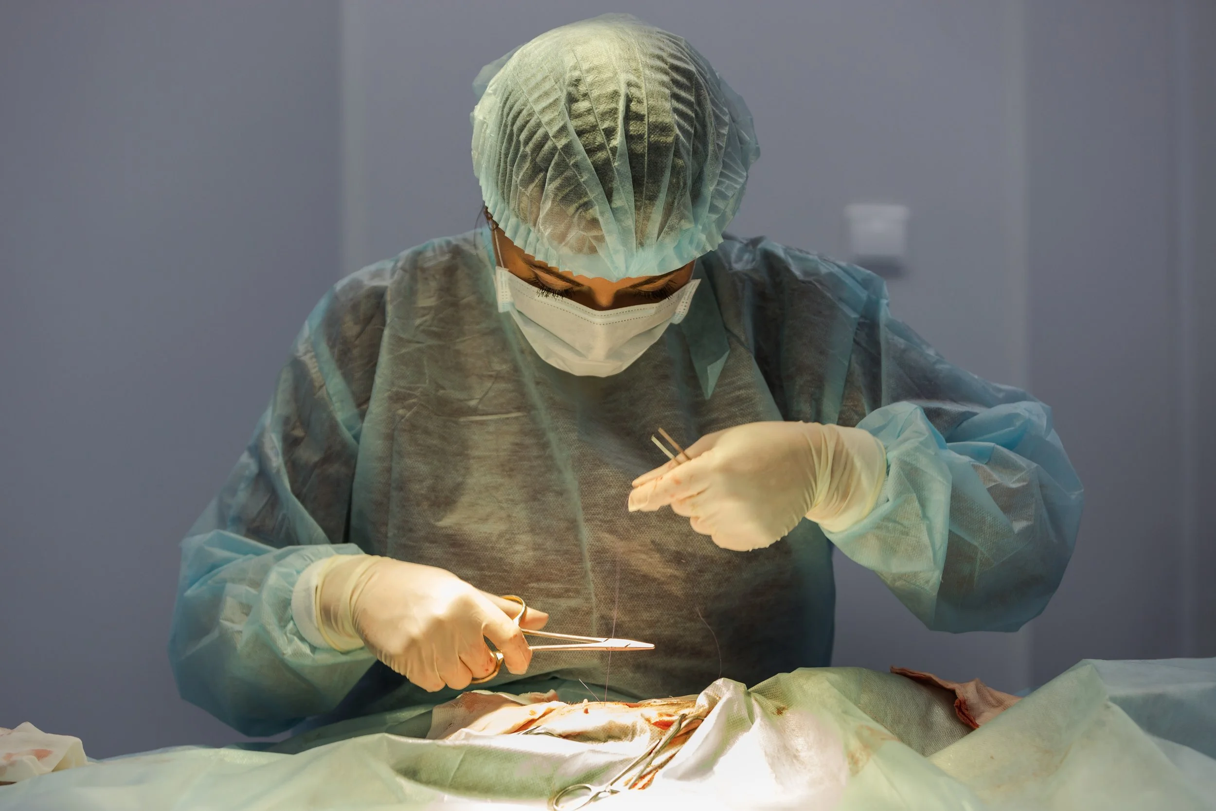 Medical professional performing surgery in an operating room.