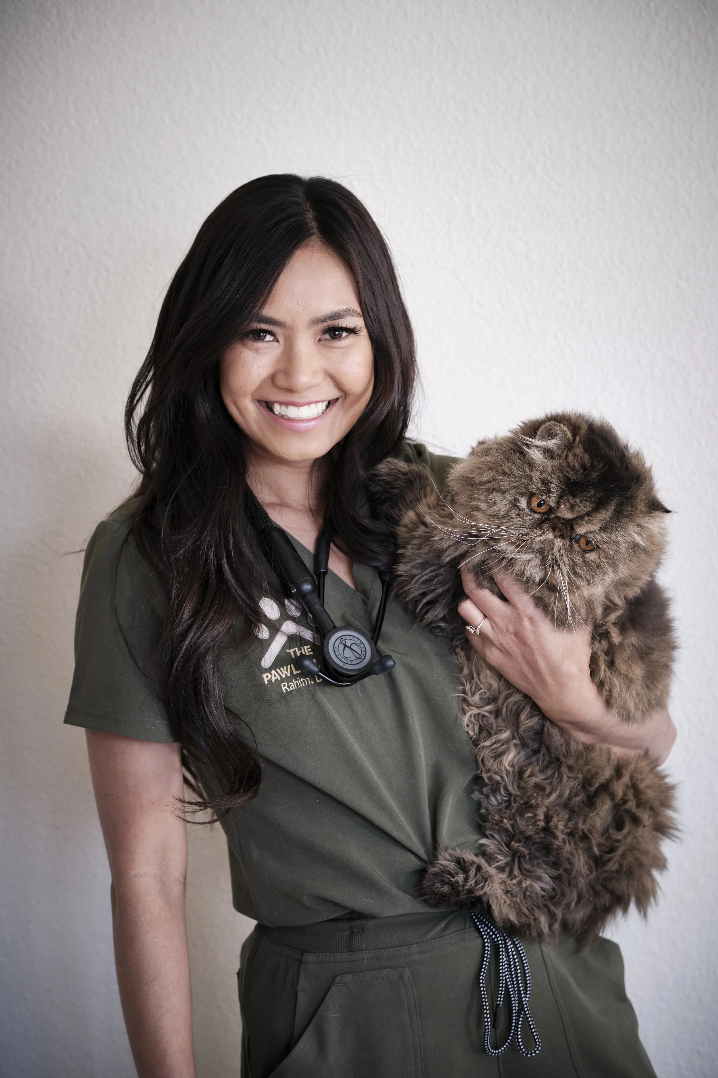 Dr. Rahim, co-owner and veterinarian at Pawlyclinic, holding a long-haired cat — providing mobile and in-clinic veterinary care in Denver.