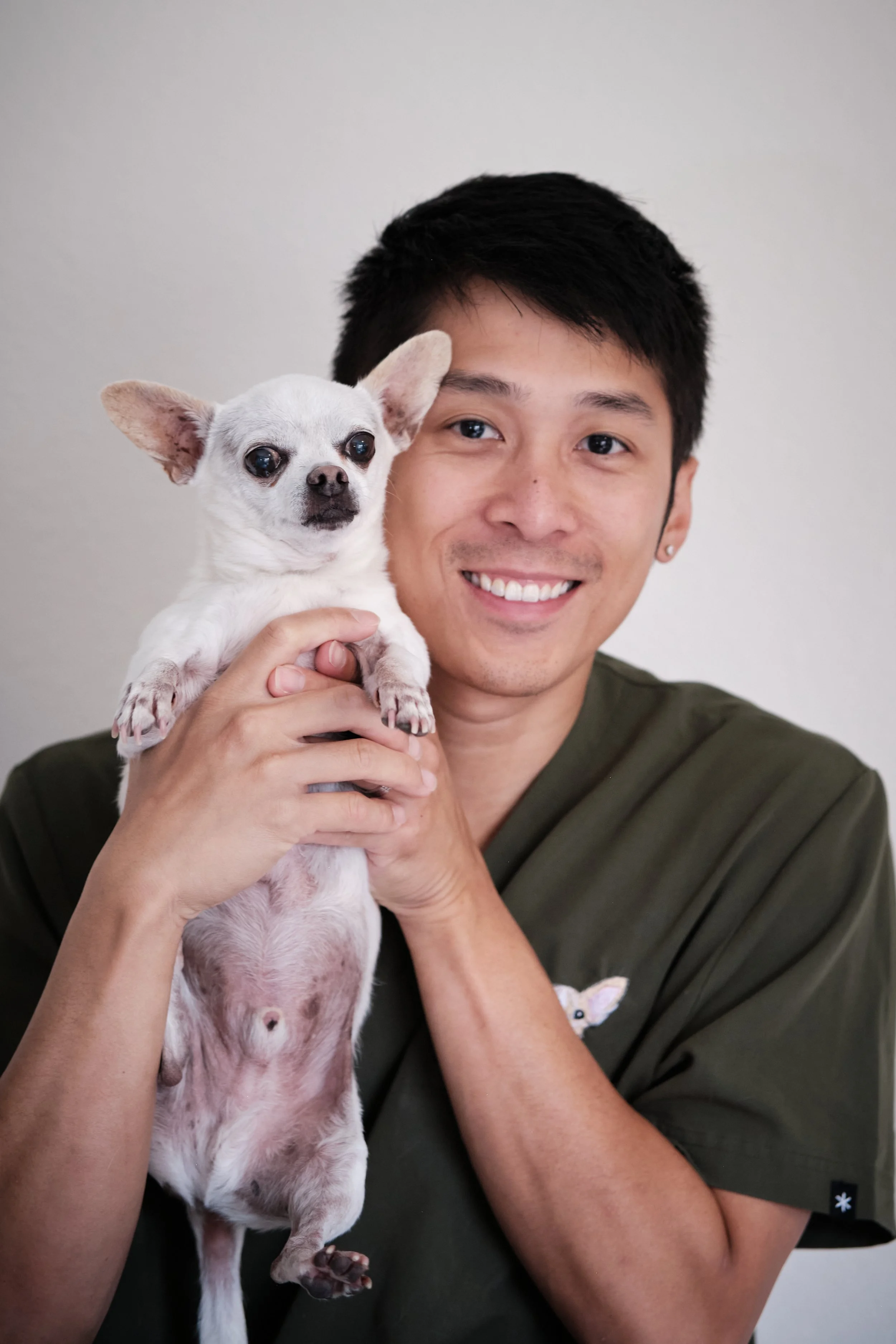 Steve, co-owner of Pawlyclinic, smiling while holding a small white dog — helping lead mobile veterinary care and client services in Denver.