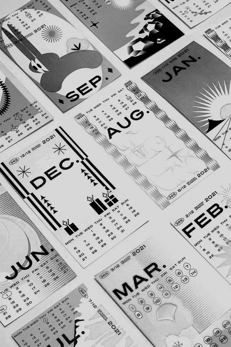 Multiple black-and-white calendar pages for the year 2021 scattered, showing months from September to July, with some featuring illustrations of the sun, moon, and stylized graphics.