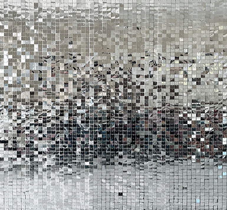 Close-up of a mosaic made from tiny reflective square tiles, creating a shimmering, pixelated effect.