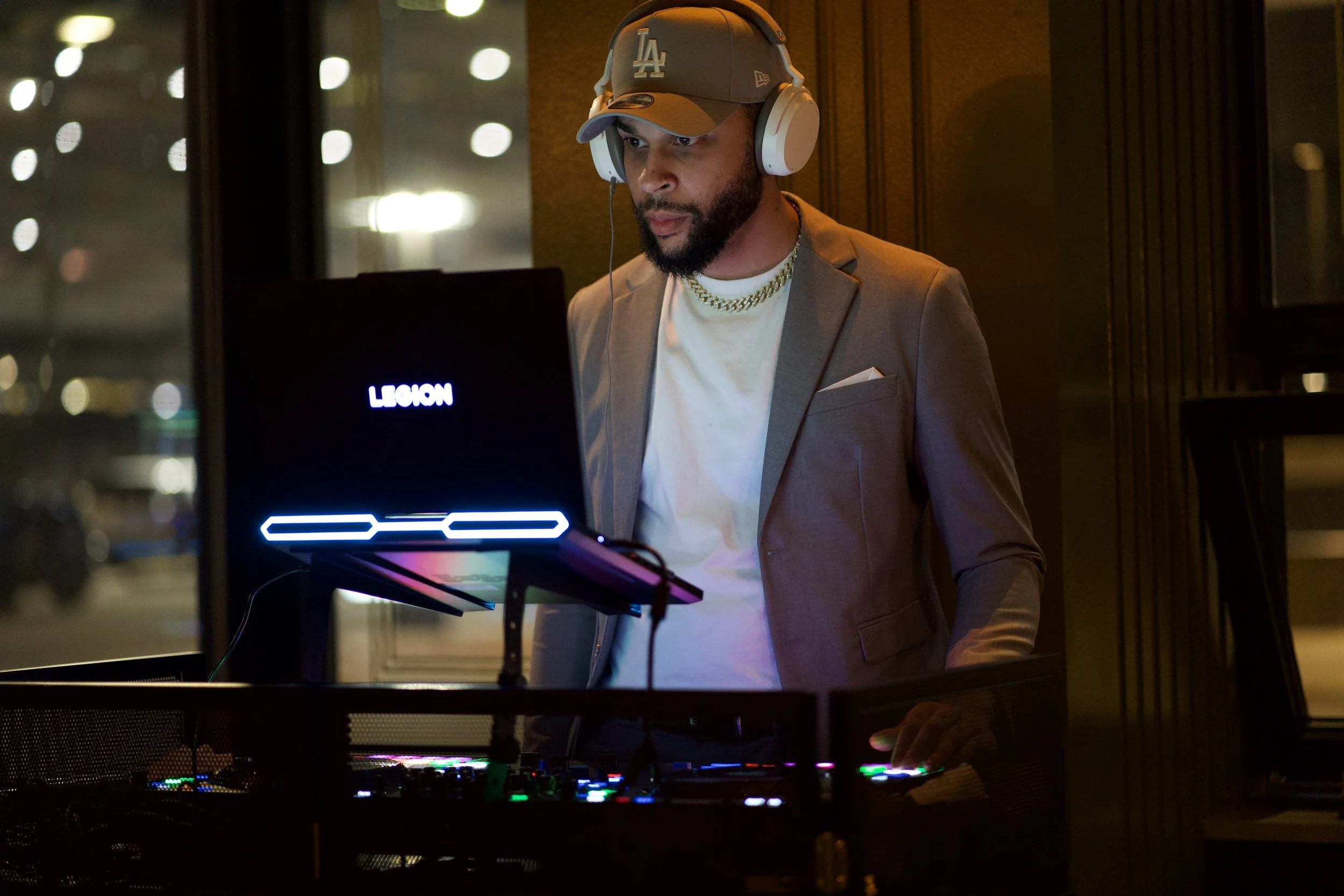 DJ Avery wearing headphones and a suit, mixing at The Treasury in Downtown Sioux Falls