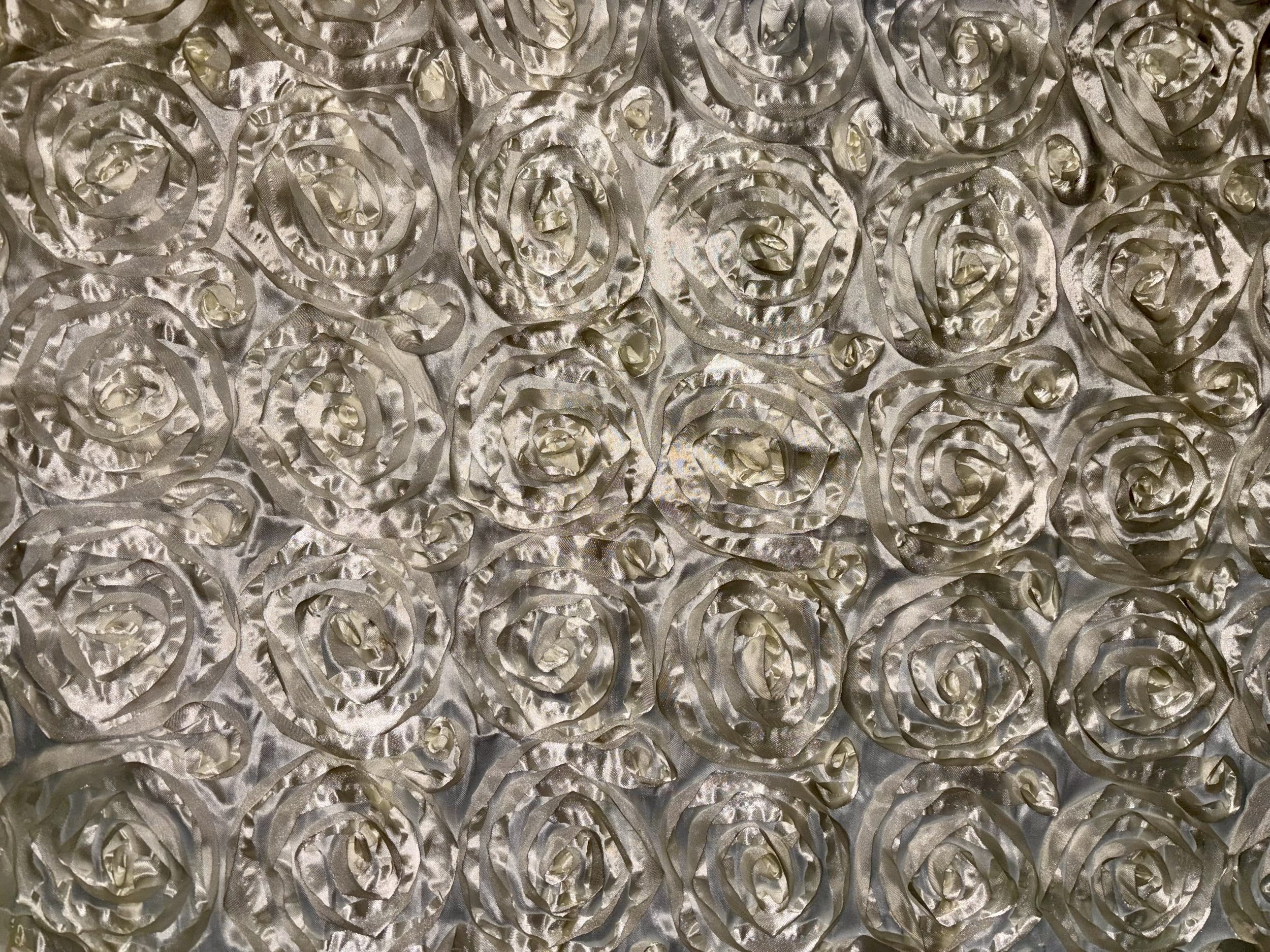 A sheet of metallic silver fabric with a pattern of embossed roses.