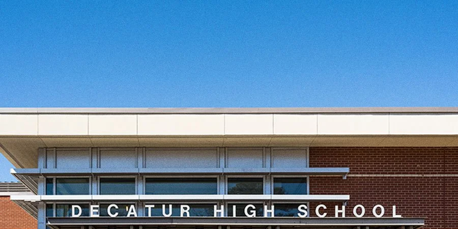 The facade of Decatur High School building with clear blue sky in the background.
