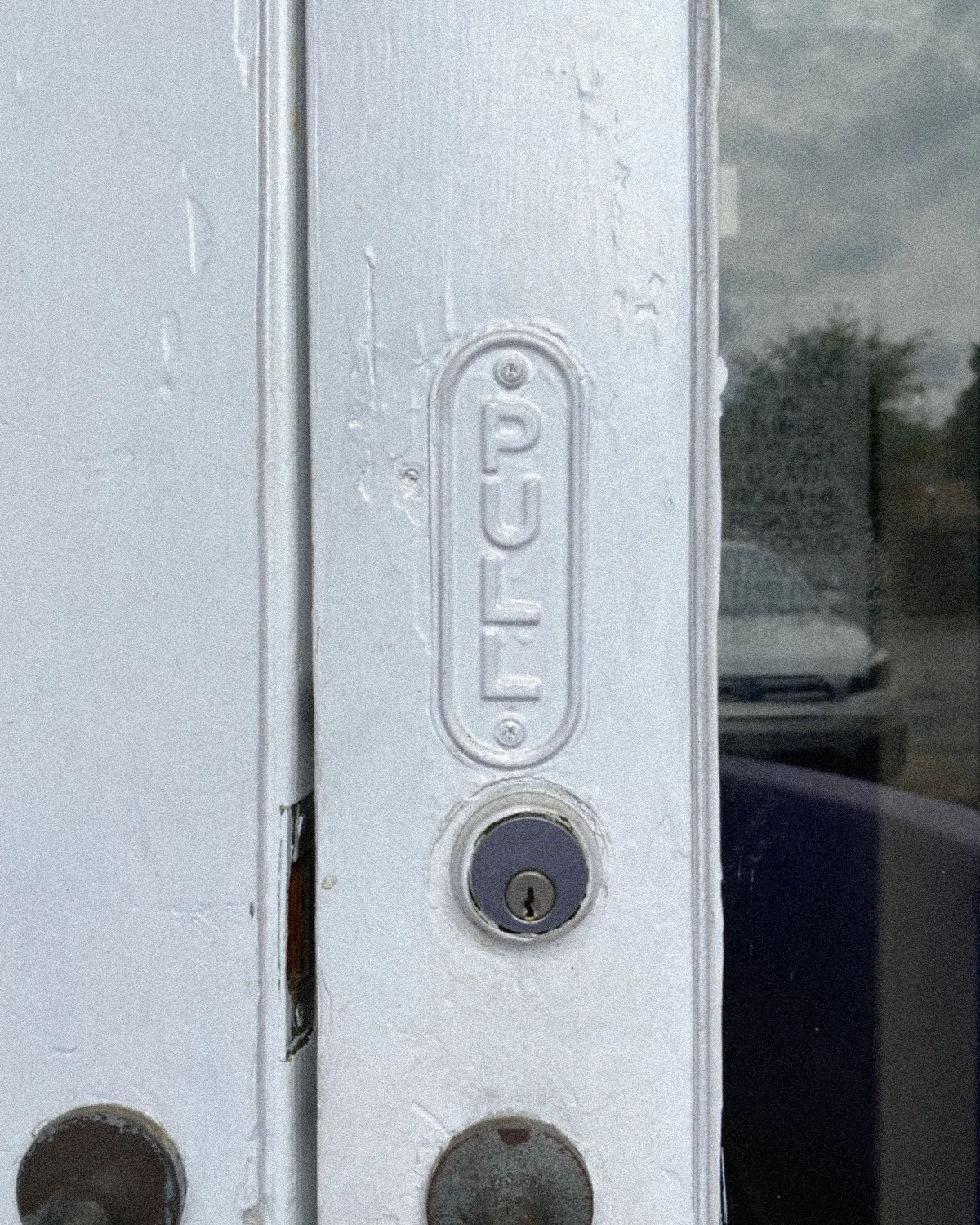 Close-up of a metal door frame with a lock and an embossed label that reads 'PUSH' in capital letters.