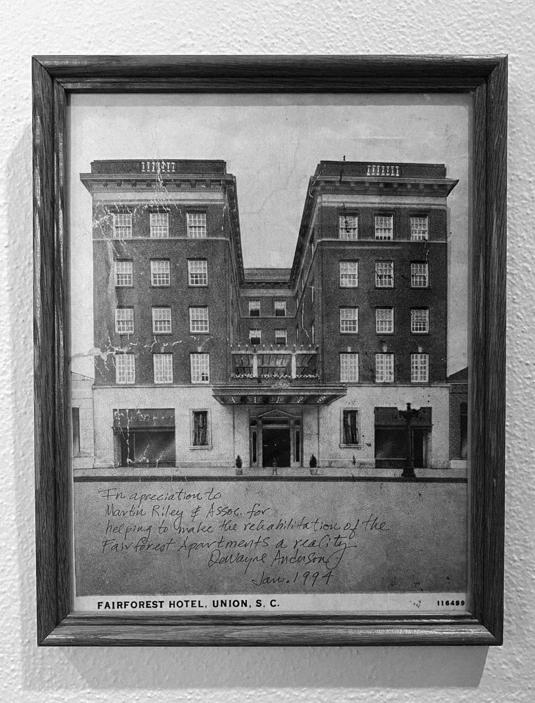 Black and white photograph of the Fairforest Hotel in Union, South Carolina, framed and hanging on a wall, with handwritten dedication and construction date.