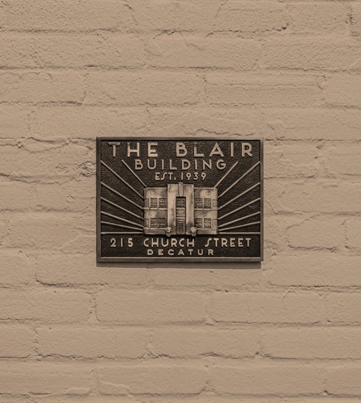 Plaque on a white brick wall for The Blair Building, established in 1939, located at 215 Church Street, Decatur.