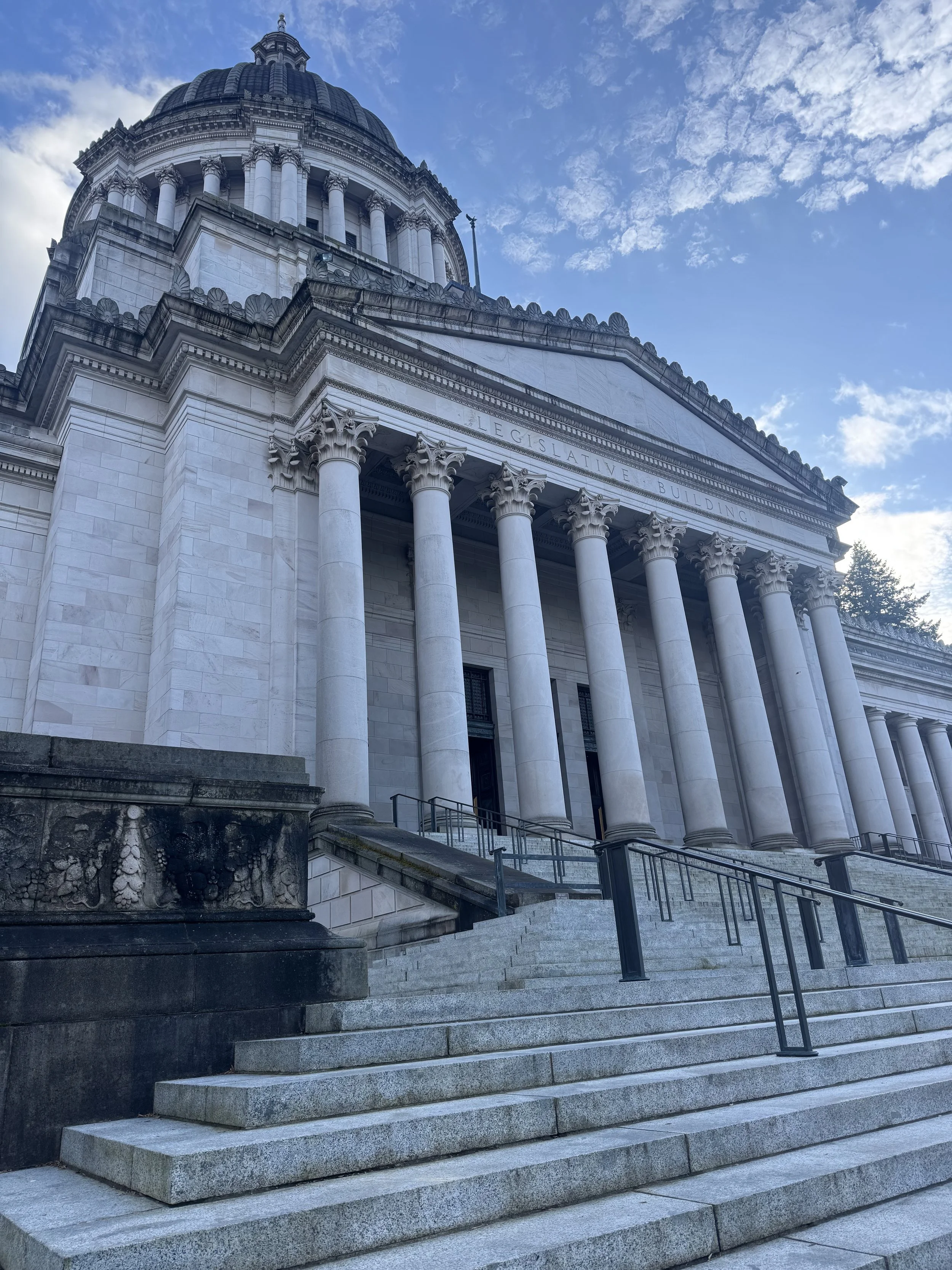 Front view of a classical style government building with large columns, steps leading up to the entrance, and a dome on top, labeled as 'the Washington State Legislative Building'.