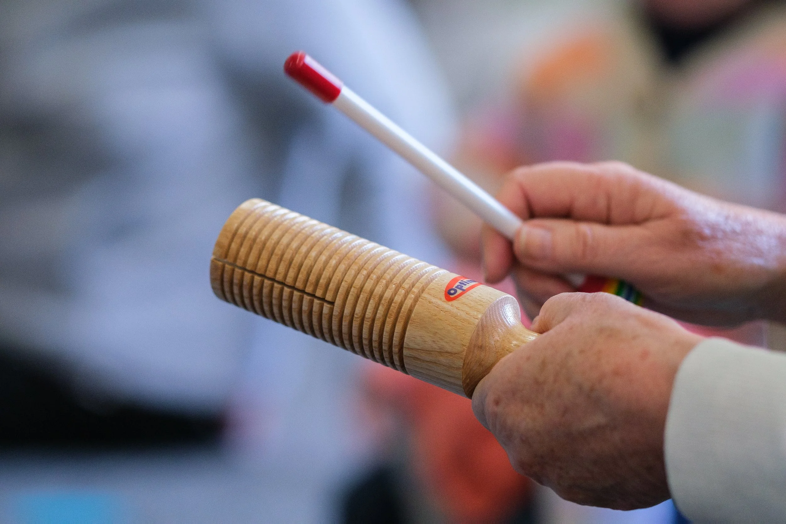 Close-up of a hand holding a wooden guiro.