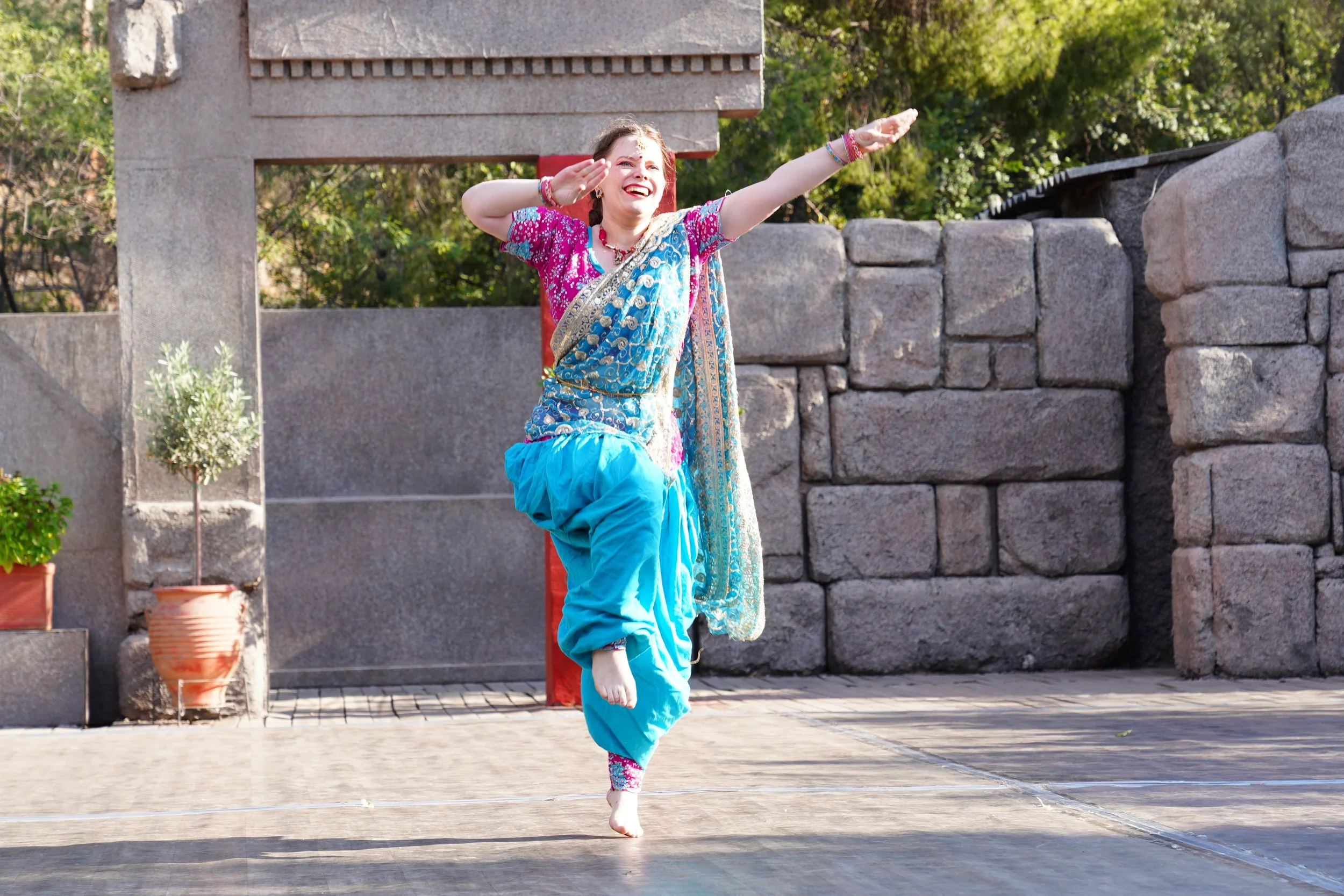 Mouki dans un ensemble bleu et fuschia danse à une compétition de Bollywood à Athènes