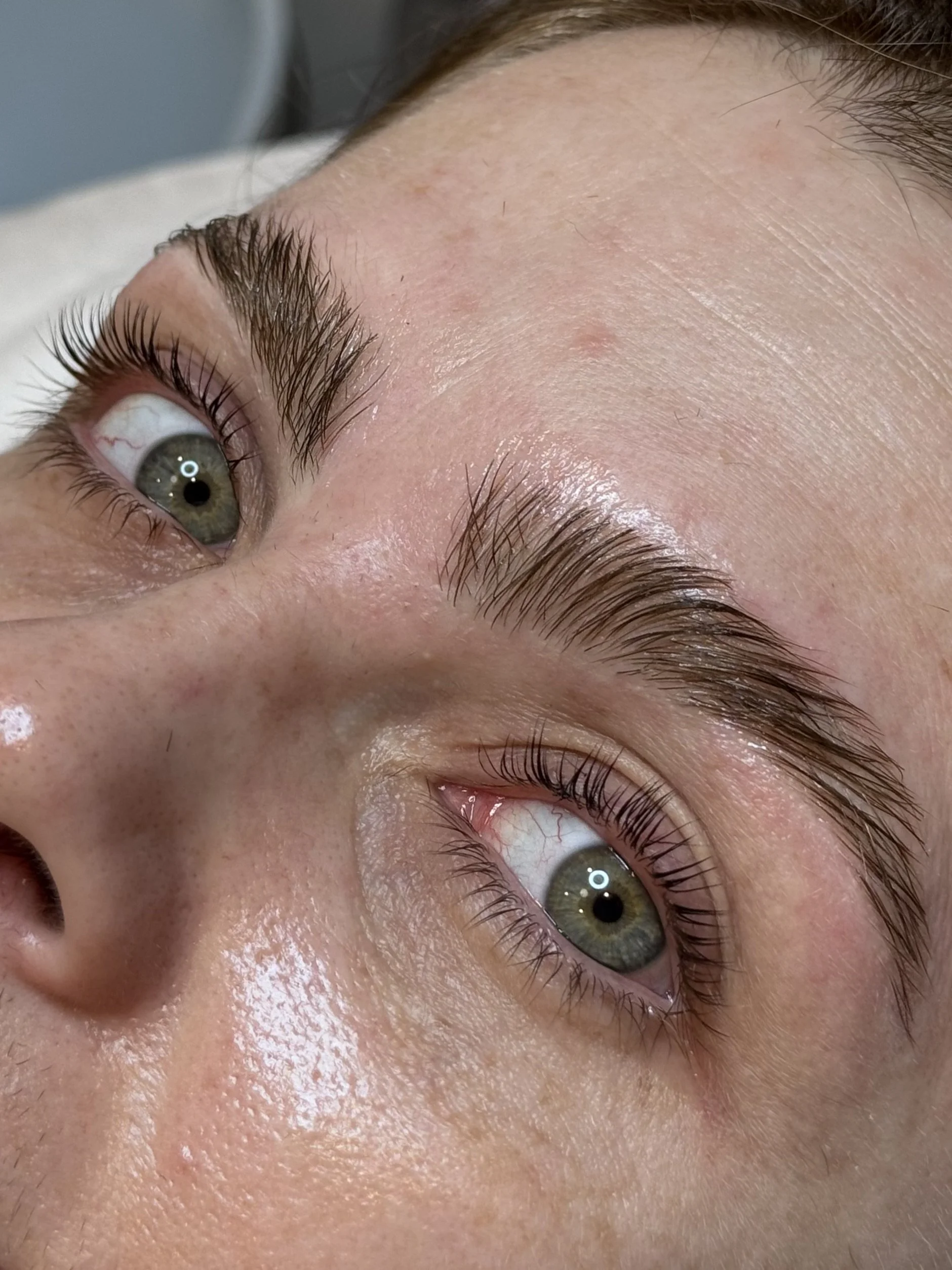 Close-up of a person's face focusing on the eyes, showing detailed eyelashes, skin texture, and eye color, with natural lighting.