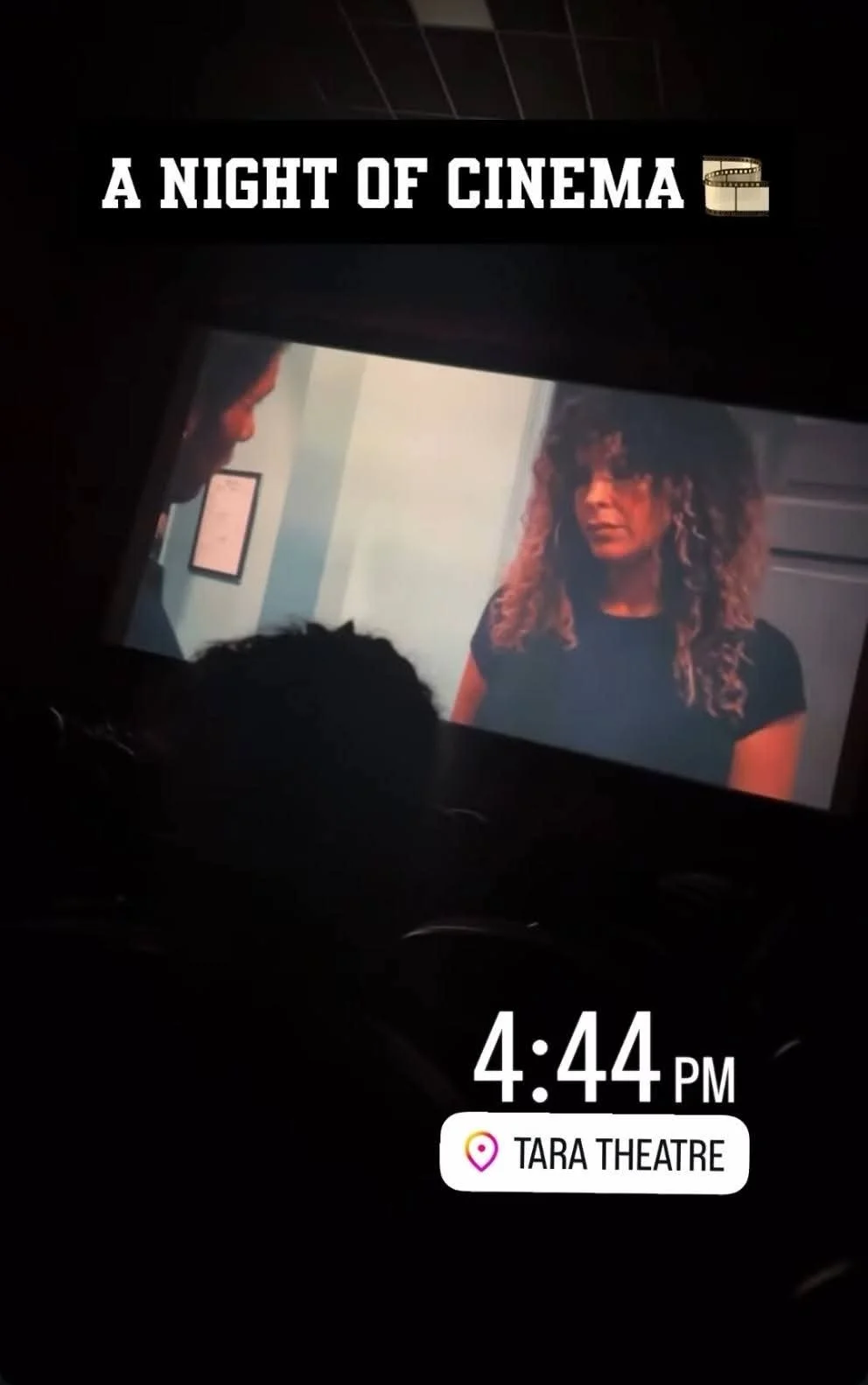 The image shows a movie screen at Tara Theatre displaying the title 'A Night of Cinema' with a film reel icon. There is a person with curly hair and earrings on the screen, and the date and time are 4:44 PM.