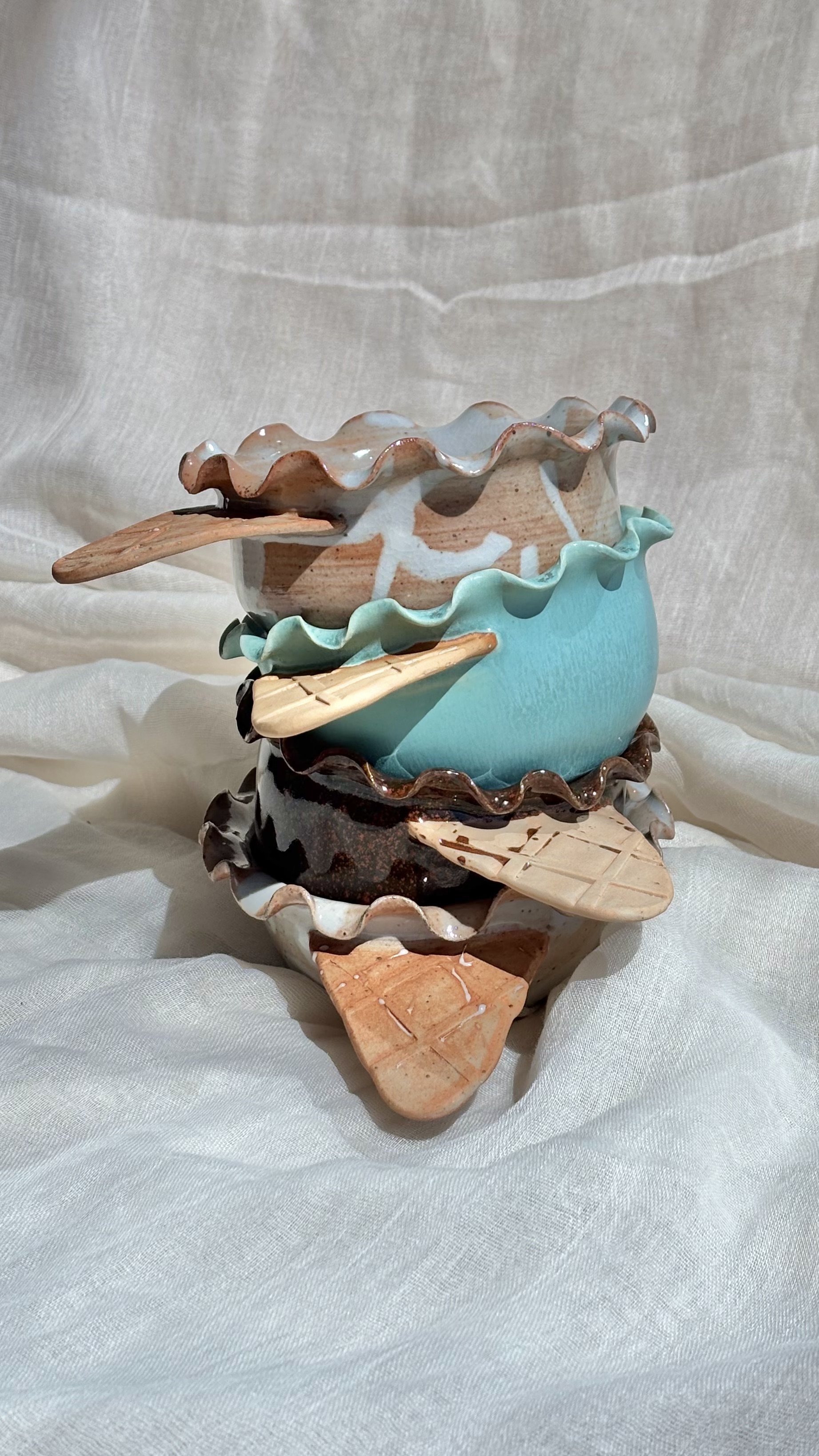 Stacked handmade ceramic waffle cone ice cream bowls in mint and brownie with a wooden spoon.jpg