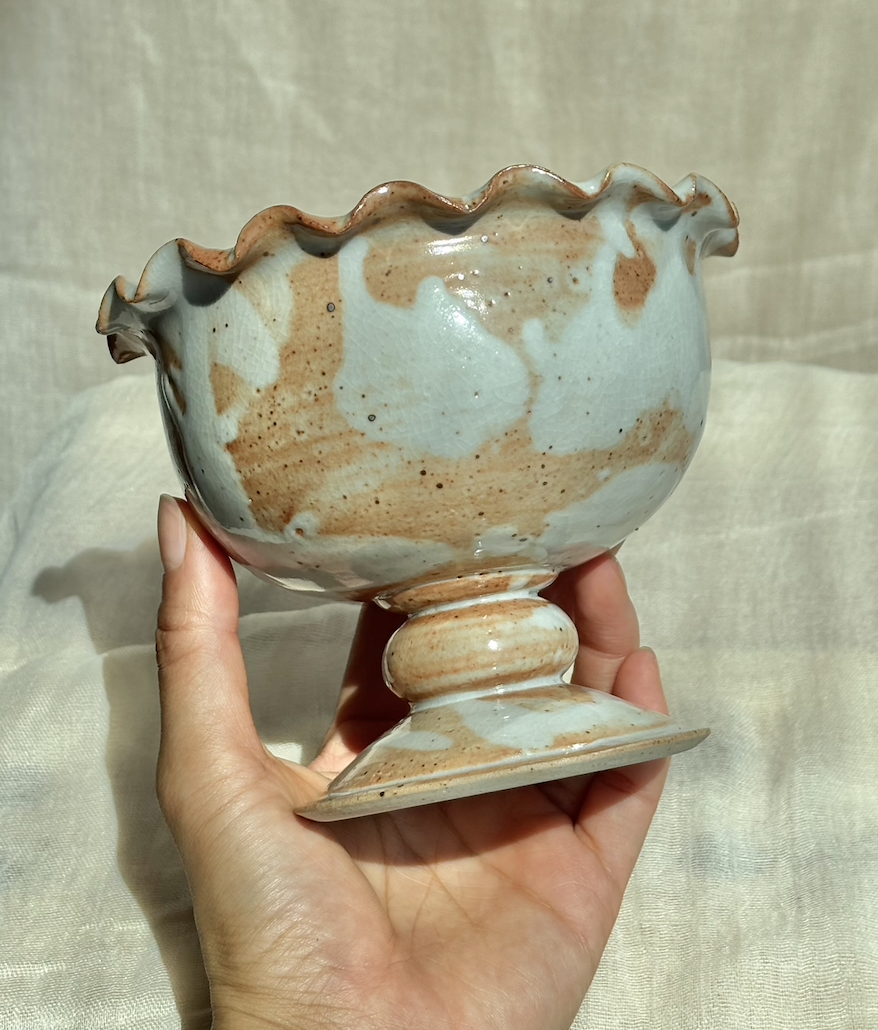 Handmade ceramic salted caramel ice cream sundae pedestal bowl with drippy glaze, held in hand.png