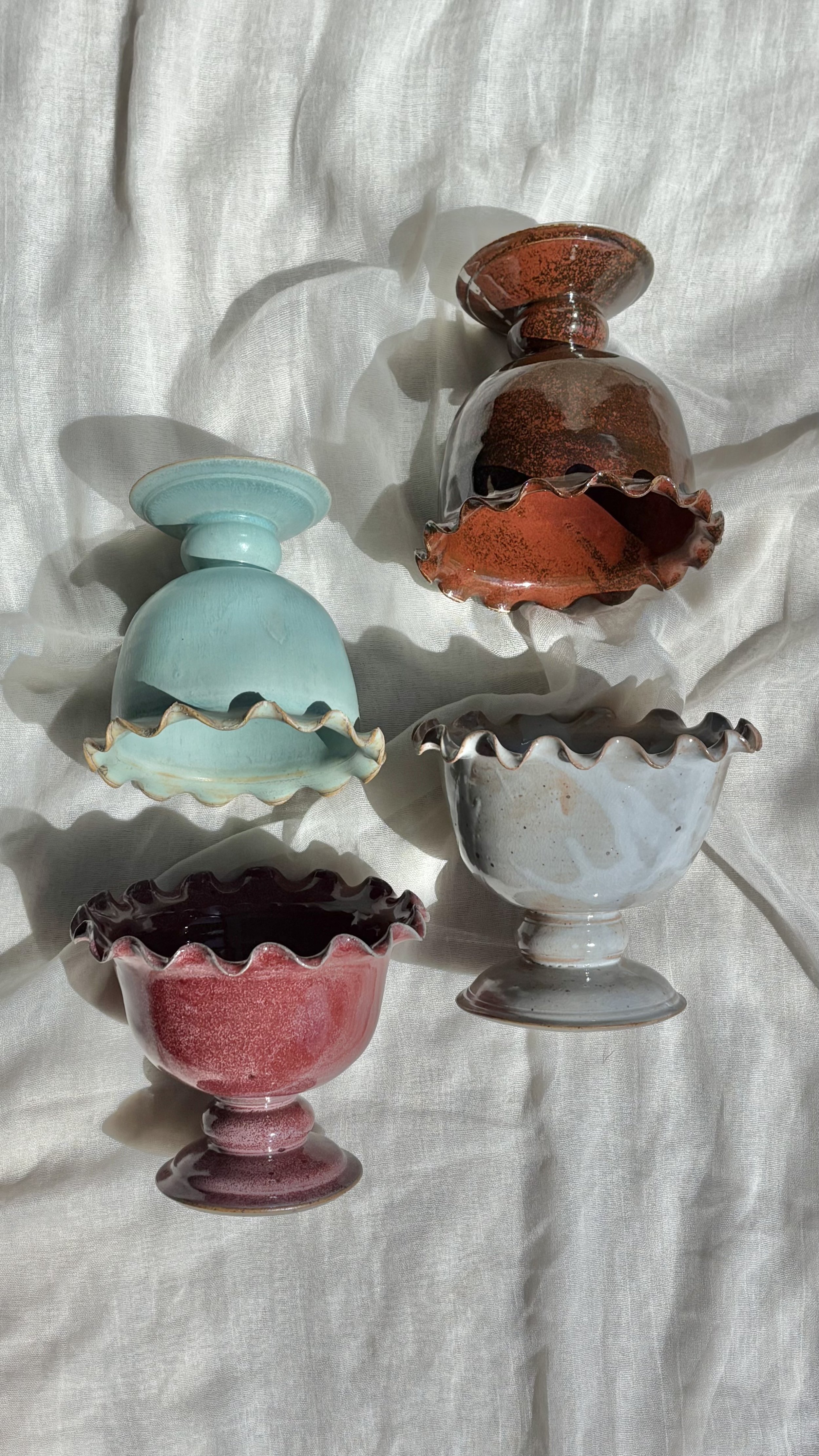 Group of handmade ceramic ice cream sundae pedestal bowls in mint, brownie, strawberry, and salted caramel.jpg