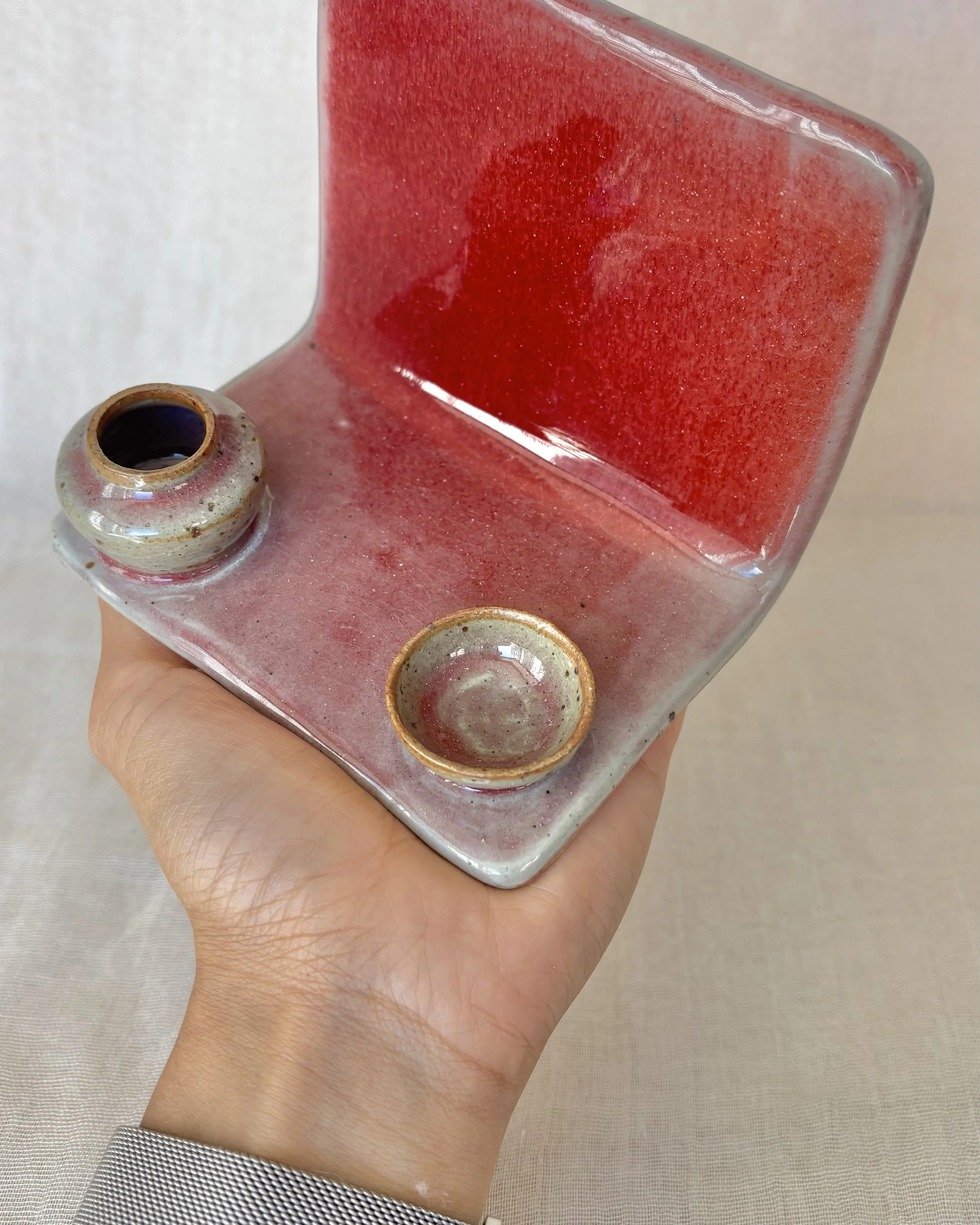handmade-pottery-phone-stand-red-glaze-in-hand.jpeg