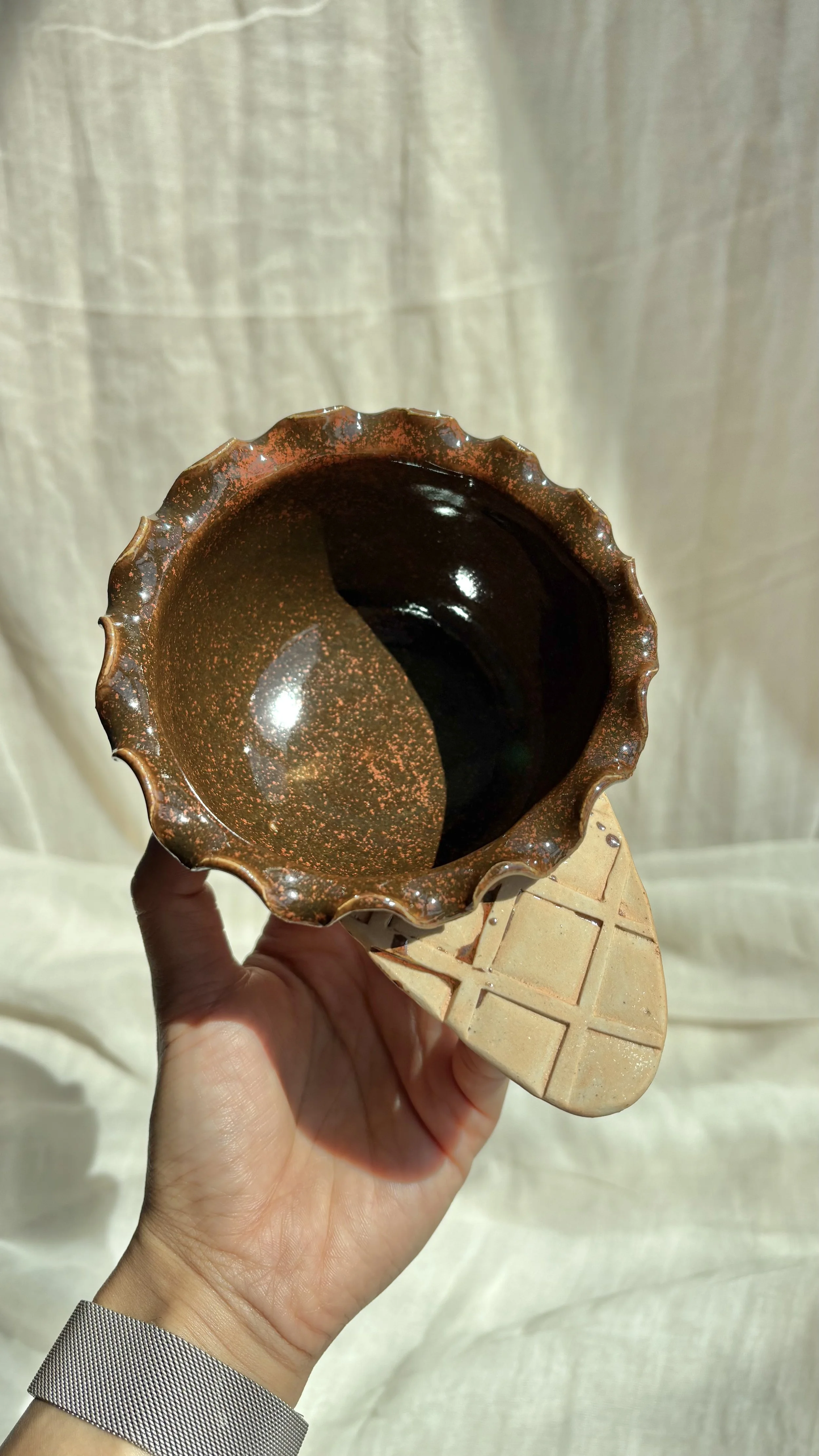 Handmade ceramic chocolate brownie waffle cone ice cream bowl with carved waffle texture, held in hand.jpg