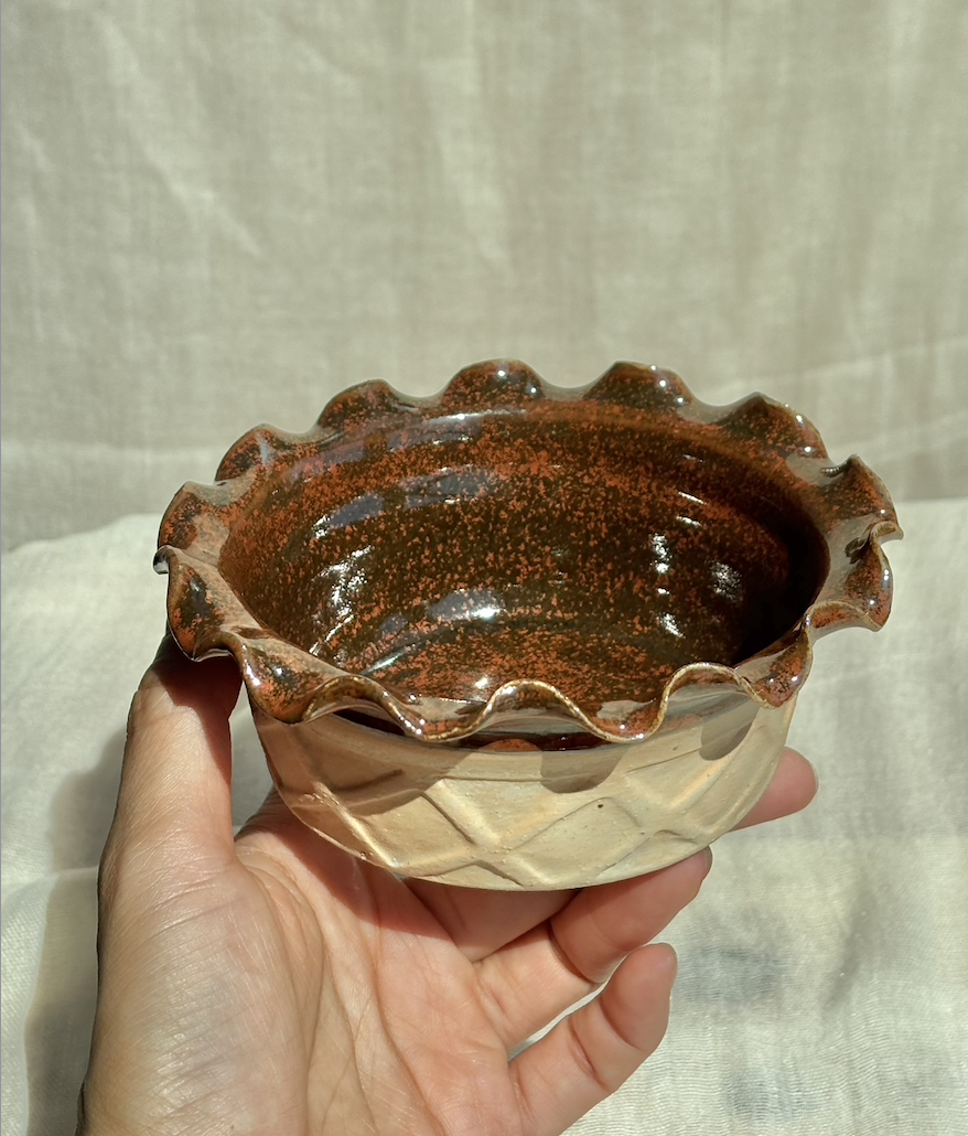 Handmade ceramic chocolate brownie waffle cup ice cream bowl with carved waffle texture, held in hand.png