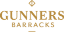 Gunners Barracks sign with black background and gold text