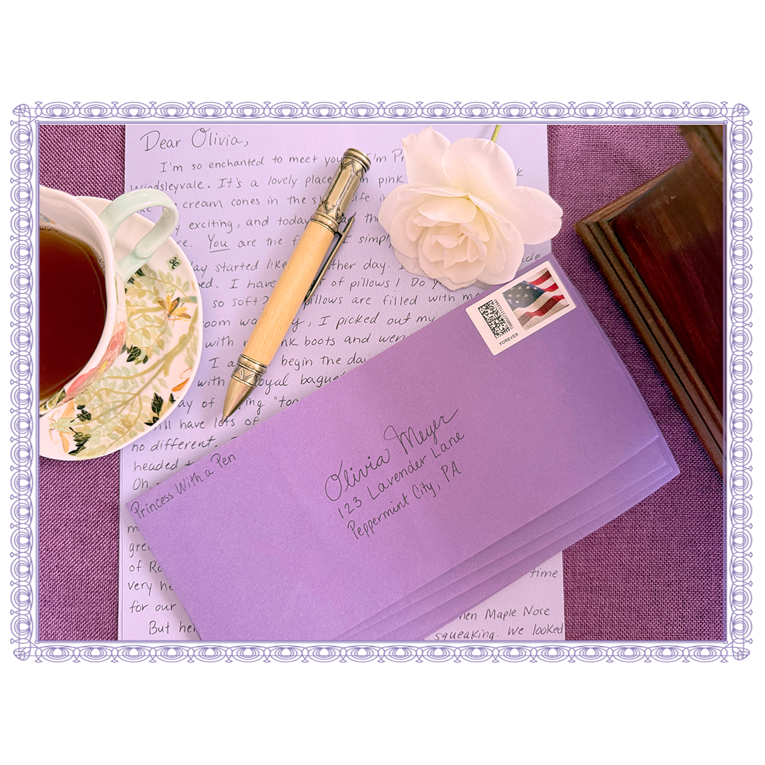 Stamped purple envelope, handwritten letter on lavender paper, white flower, teacup with tea, gold and wood pen, and a wooden box.
