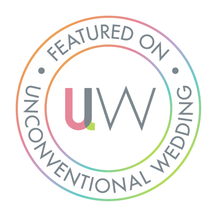 Circular badge with multicolored outline and text that reads 'Featured on Unconventional Wedding' surrounding the initials 'UW' in the center.