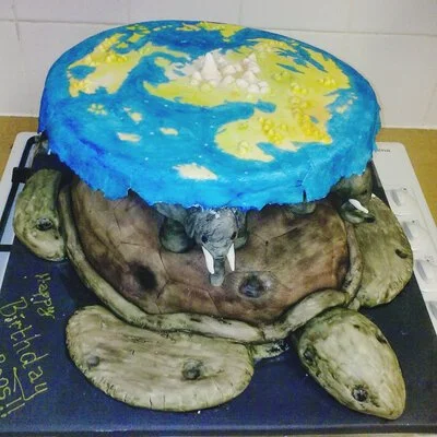 A cake designed to look like a turtle, with a flat top decorated like the Earth