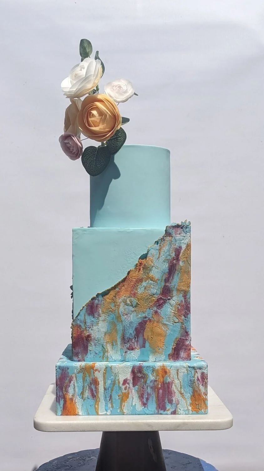 Three-tiered square cake with abstract painted design