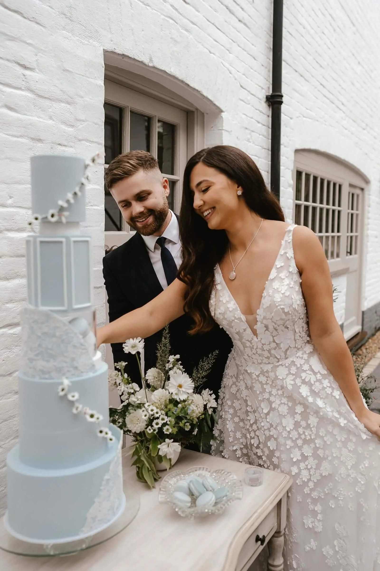 A bride and groom cut a wedding cake together