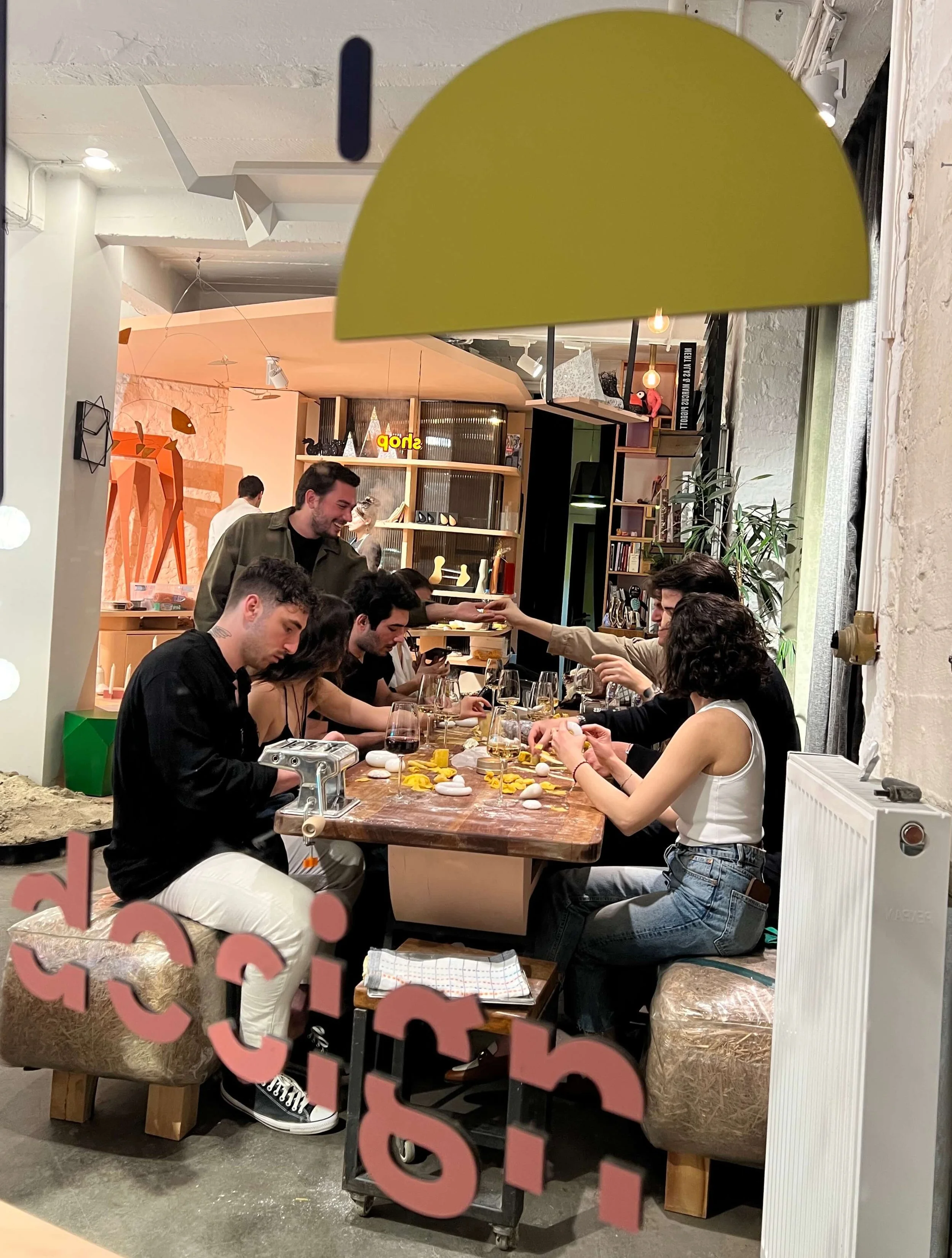 Group of people gathered around a dining table inside a modern restaurant.