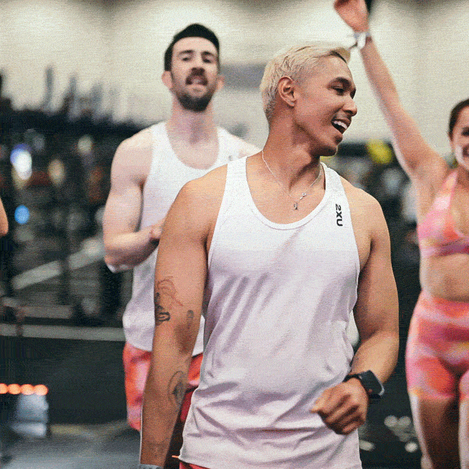 People finishing a workout at the gym, smiling and celebrating.