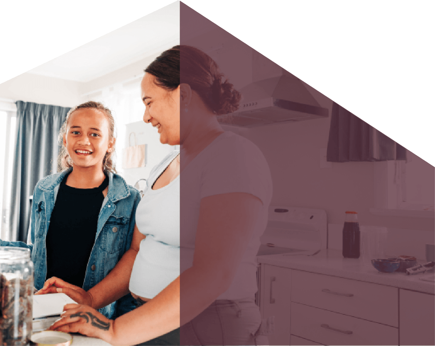 A woman and a young girl smiling and preparing food together in a bright kitchen.