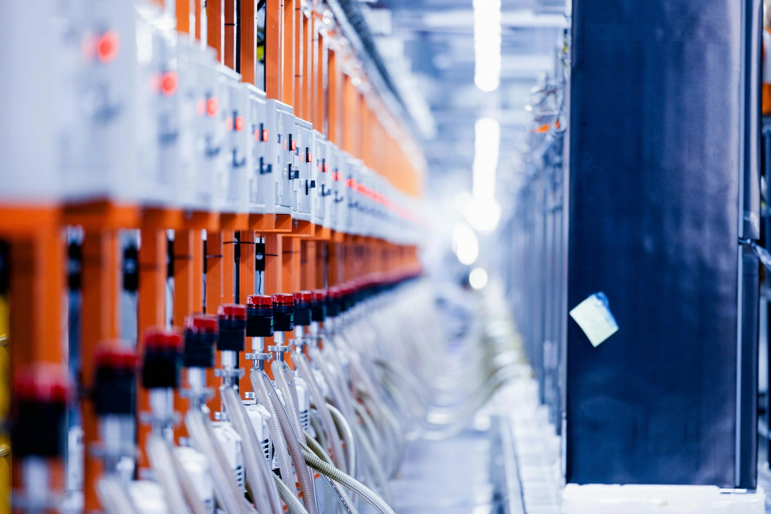 Row of electrical or data connection outlets with orange and gray components in an industrial or data center setting.