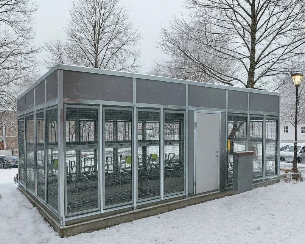 SR stort sykkelskur med kombinasjon av gitter og tette veggerved skole.