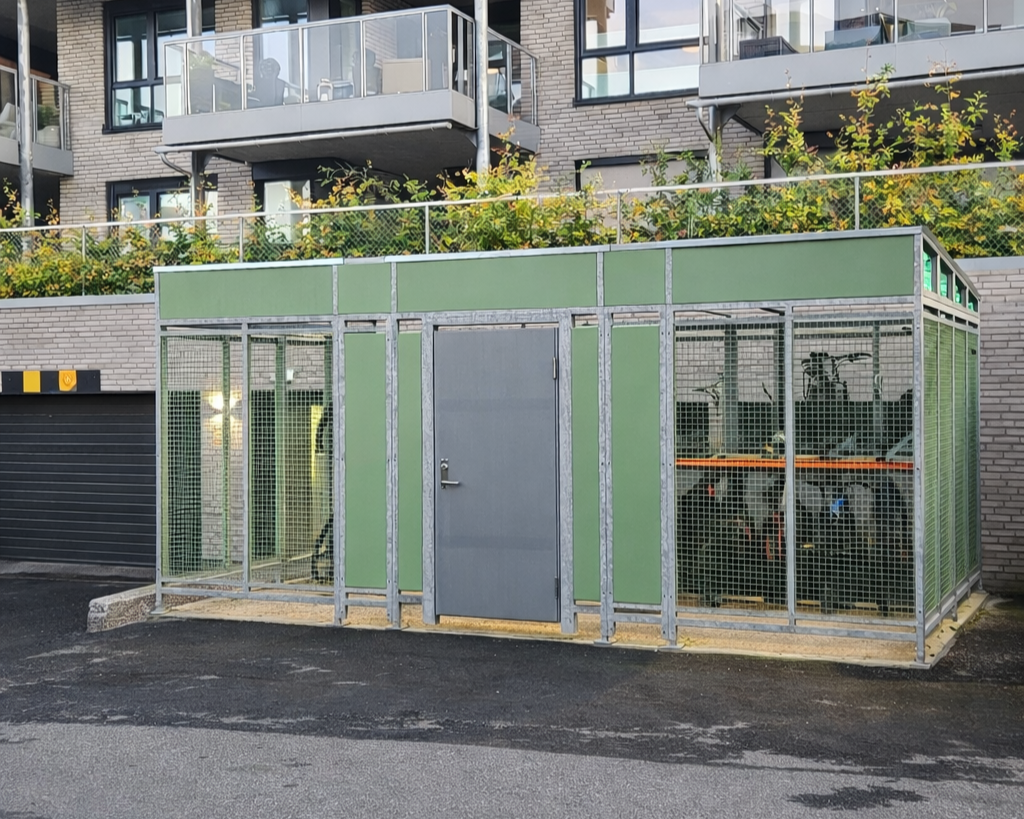 grønt skur med tette plater og gitter i moderne borettslag i Norge
