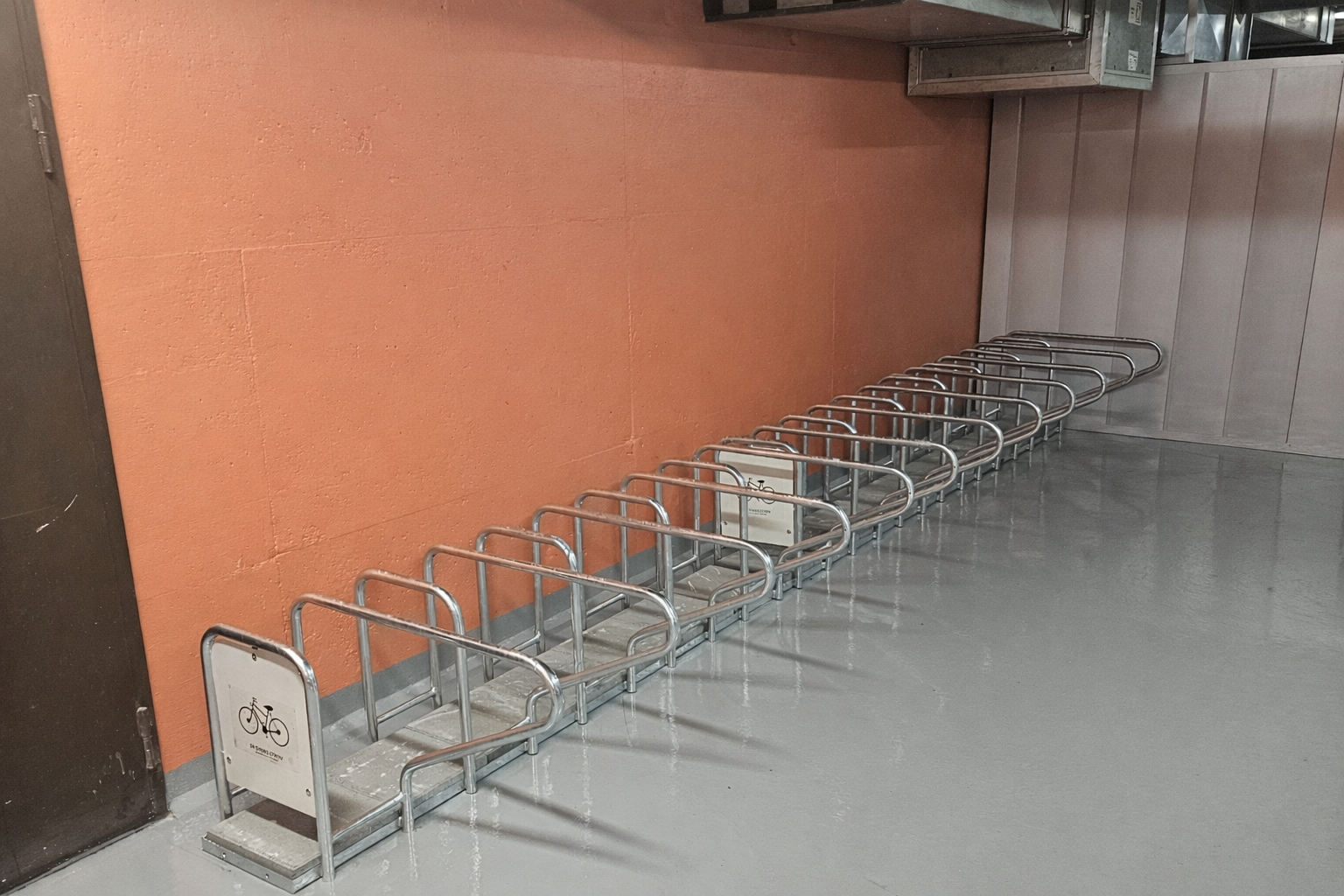 SR ensidig sykkelstativ plassert i innendørs garasjeanlegg i tilknytning til oppgangen til leilighetene