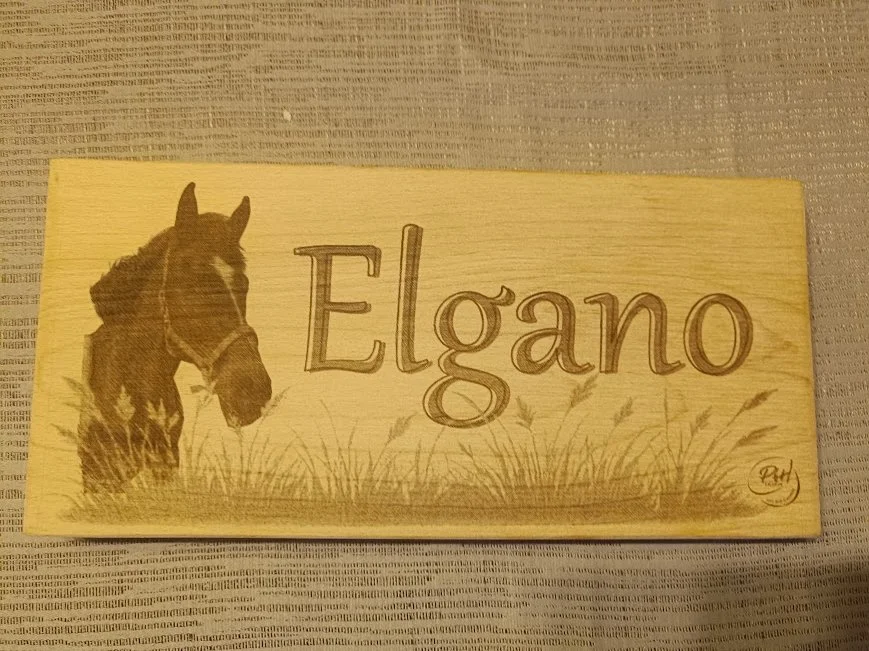 Plaque en bois avec un dessin d'un cheval et le mot "Elgano" écrit dessus.
