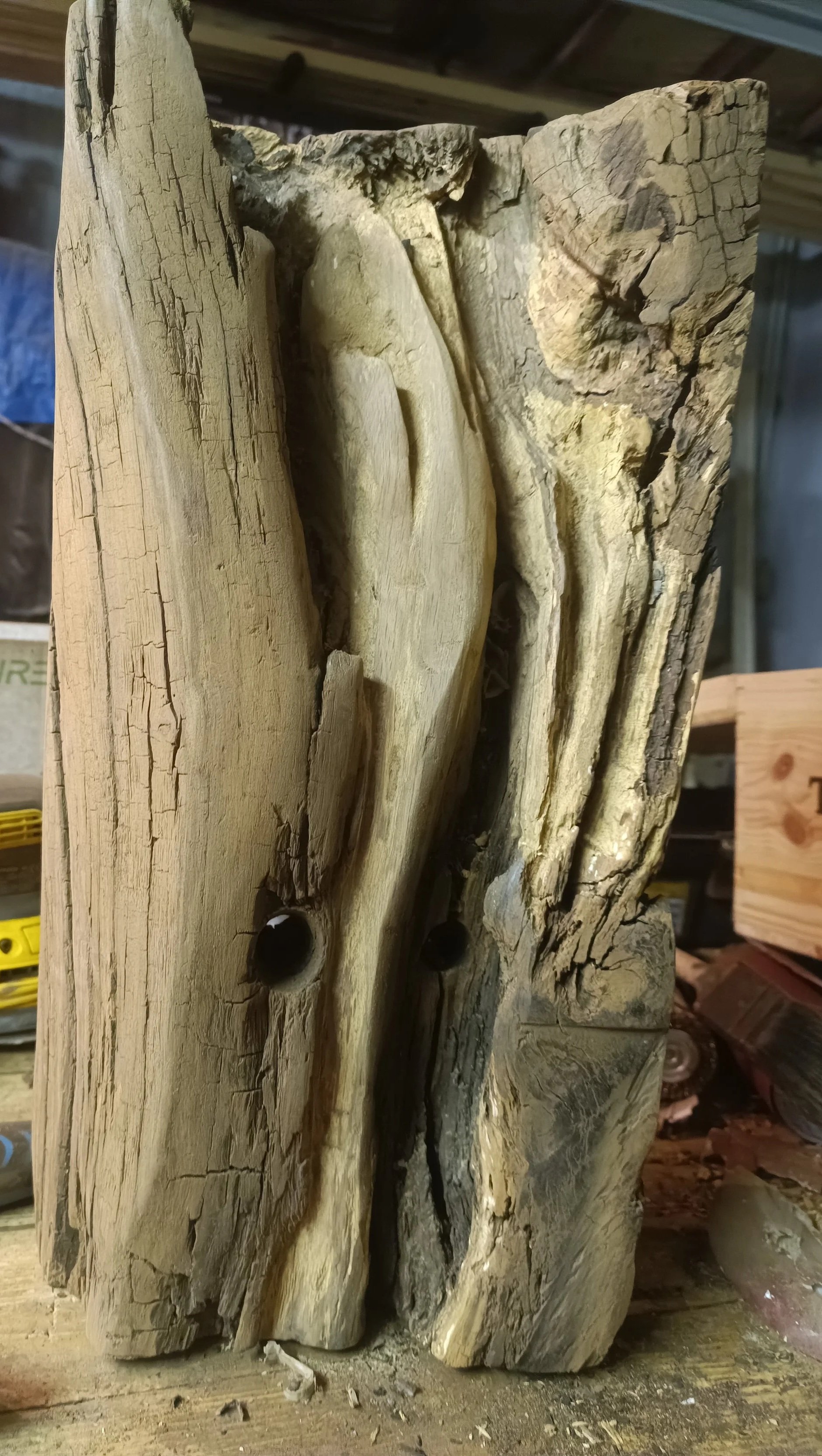 Une sculpture en bois brut et parcheminé.