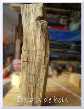 Une pièce de bois avec l'inscription "Éclats de bois" au bas.