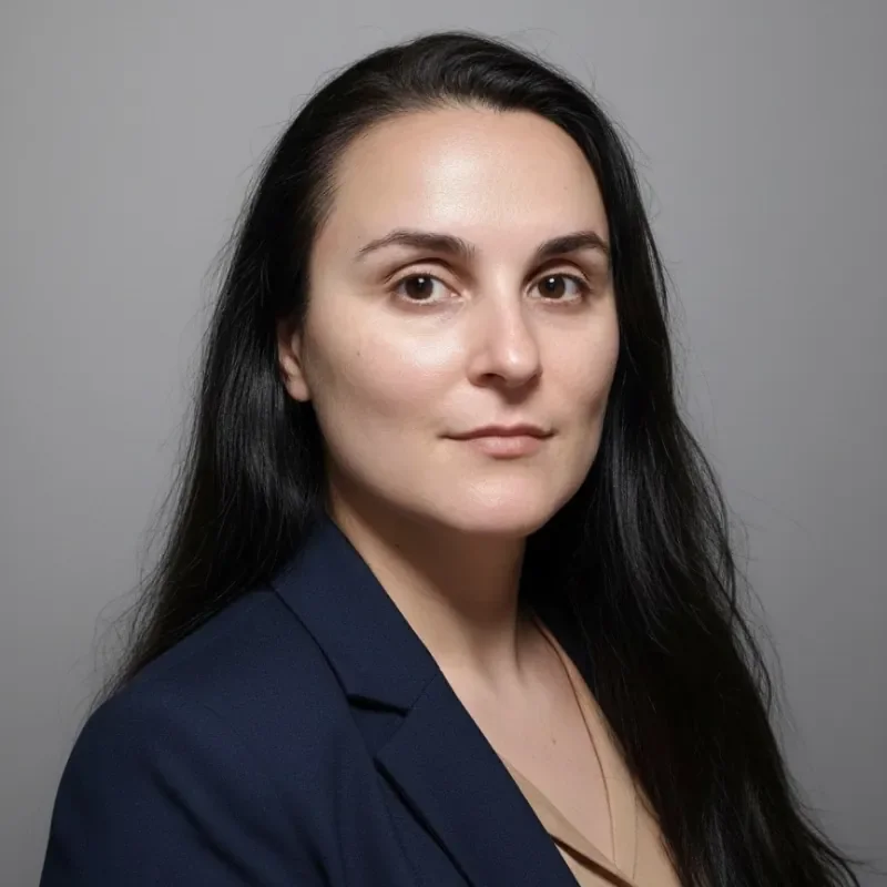Headshot of Iliyana Hristova, founder of Unburdora, smiling softly and looking at the camera, conveying a calm, grounded and approachable presence for one-to-one conversations.