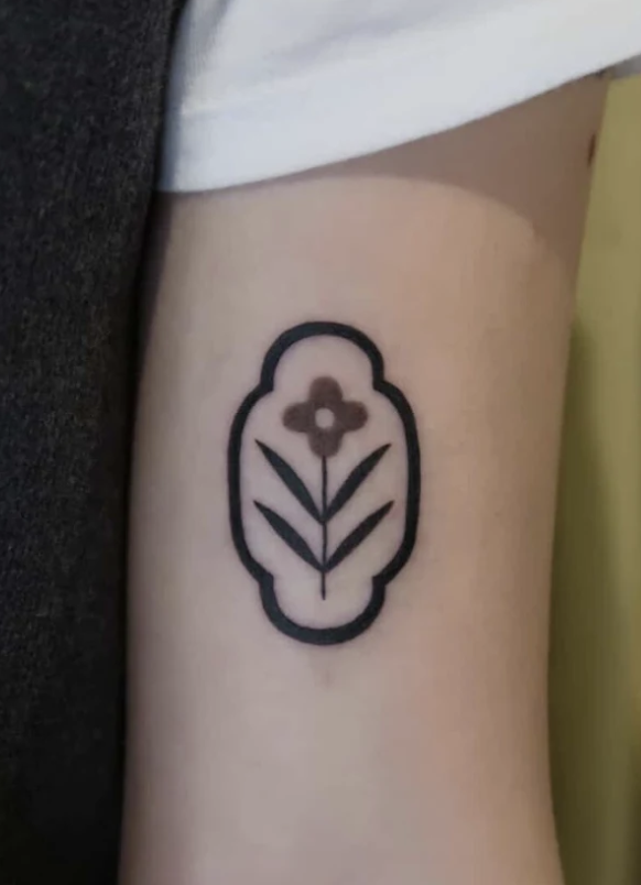 A tattoo of a floral stamp on the arm, inspired by Chinese tiles and patterns. Tattooed by Wanissa, an experienced tattoo artist known for doing unique ornamental tattoos.