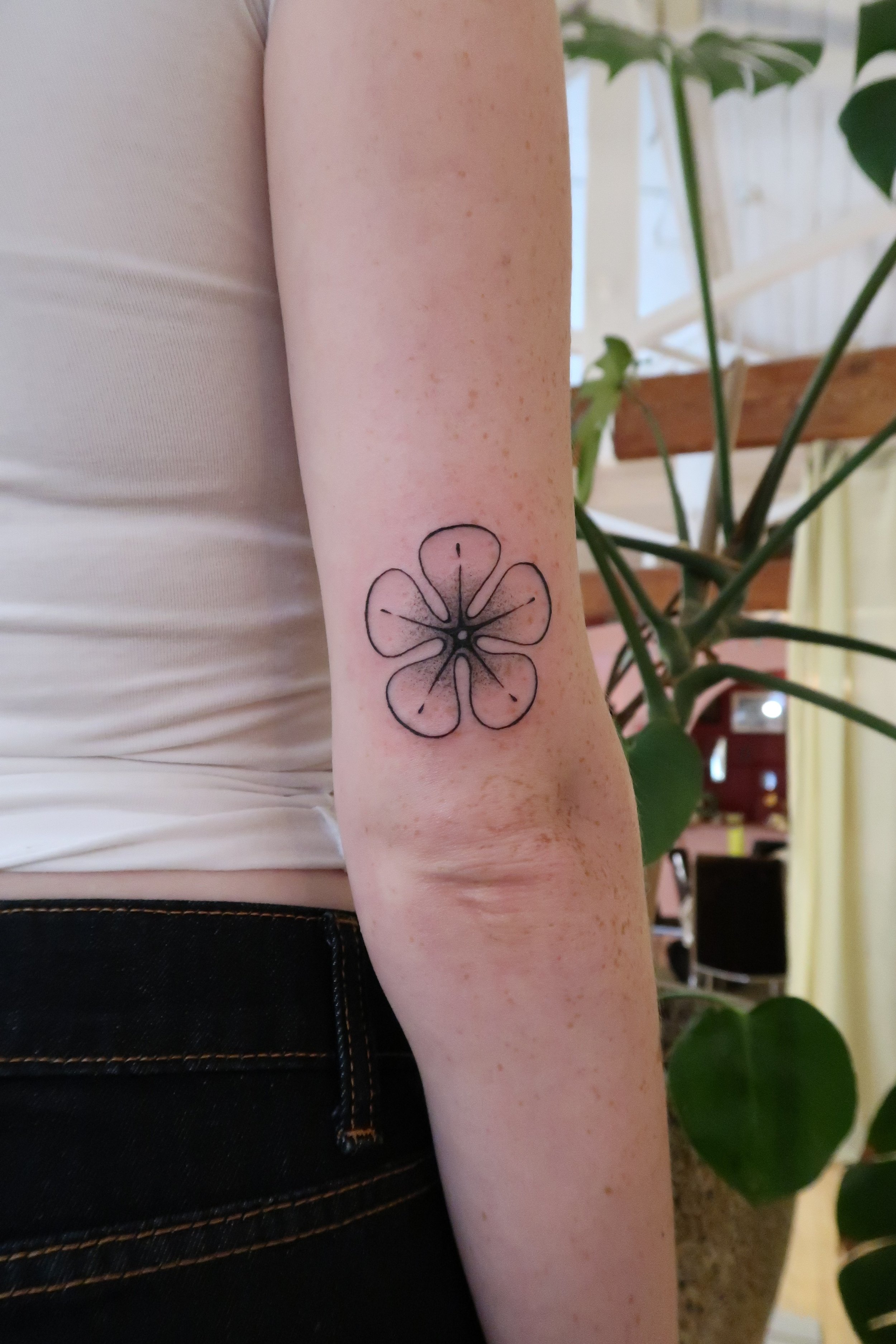 A tattoo of a delicate flower on the arm. Work by Wanissa, an Asian female tattoo artist based in Melbourne, specialise in ornamental tattoos and flowers.
