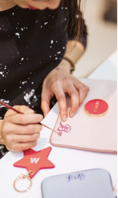 Hand painted customisation of Mimco products. Work by Wanissa, a calligraphy artist specialised in personalising luxury goods on the spot in retail settings.