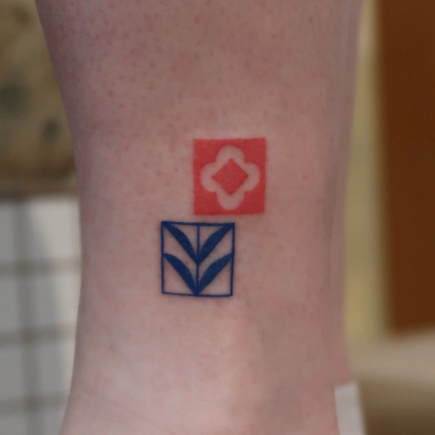 Tattoo of a red and black floral tile, inspired by multicultural patterns and ornaments. Work by Wanissa, an Asian female tattoo artist specialised in creative, delicate fineline tattoos, ornaments and tiles.