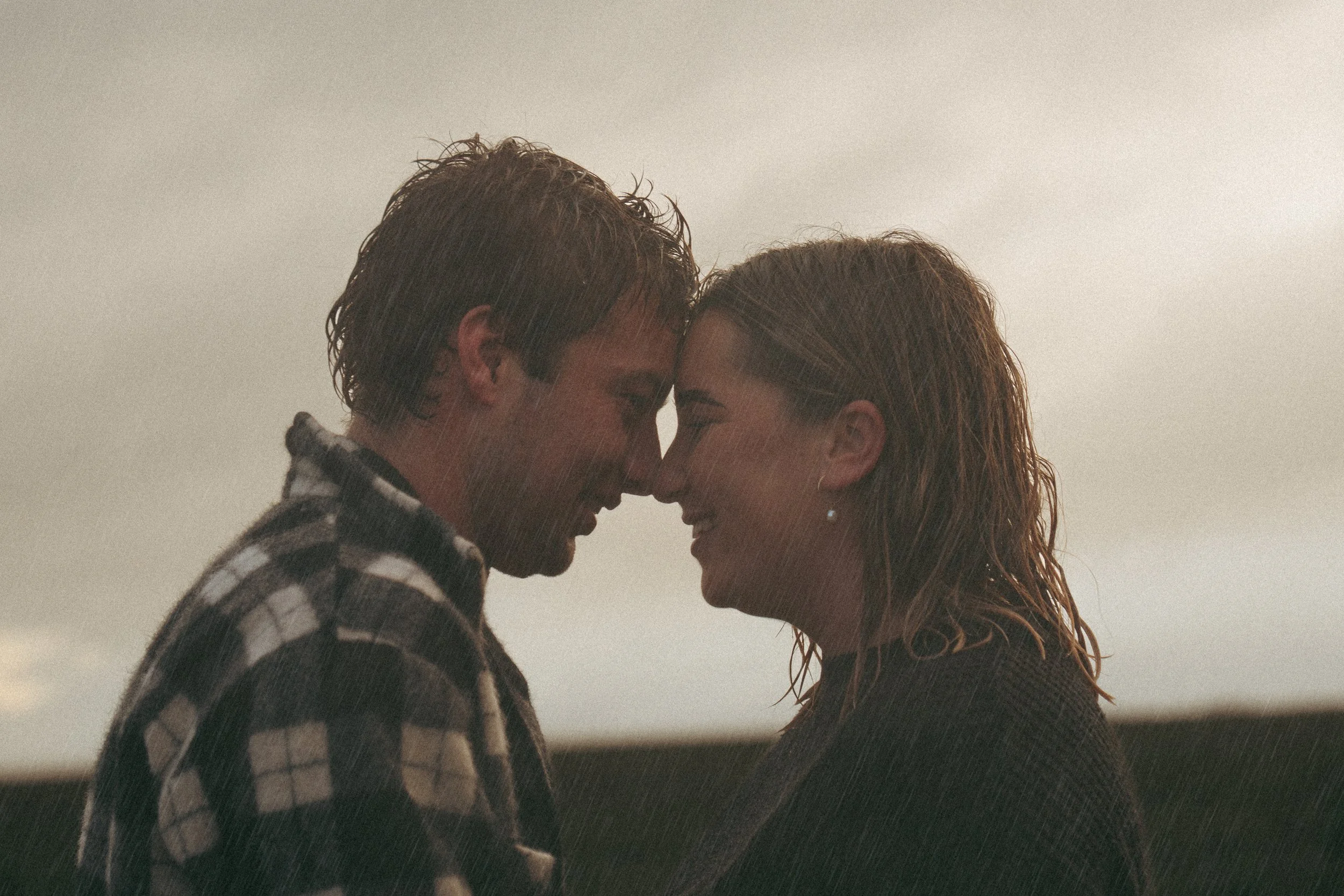 couple with their heads together in the rain during an engagement session in ceduna