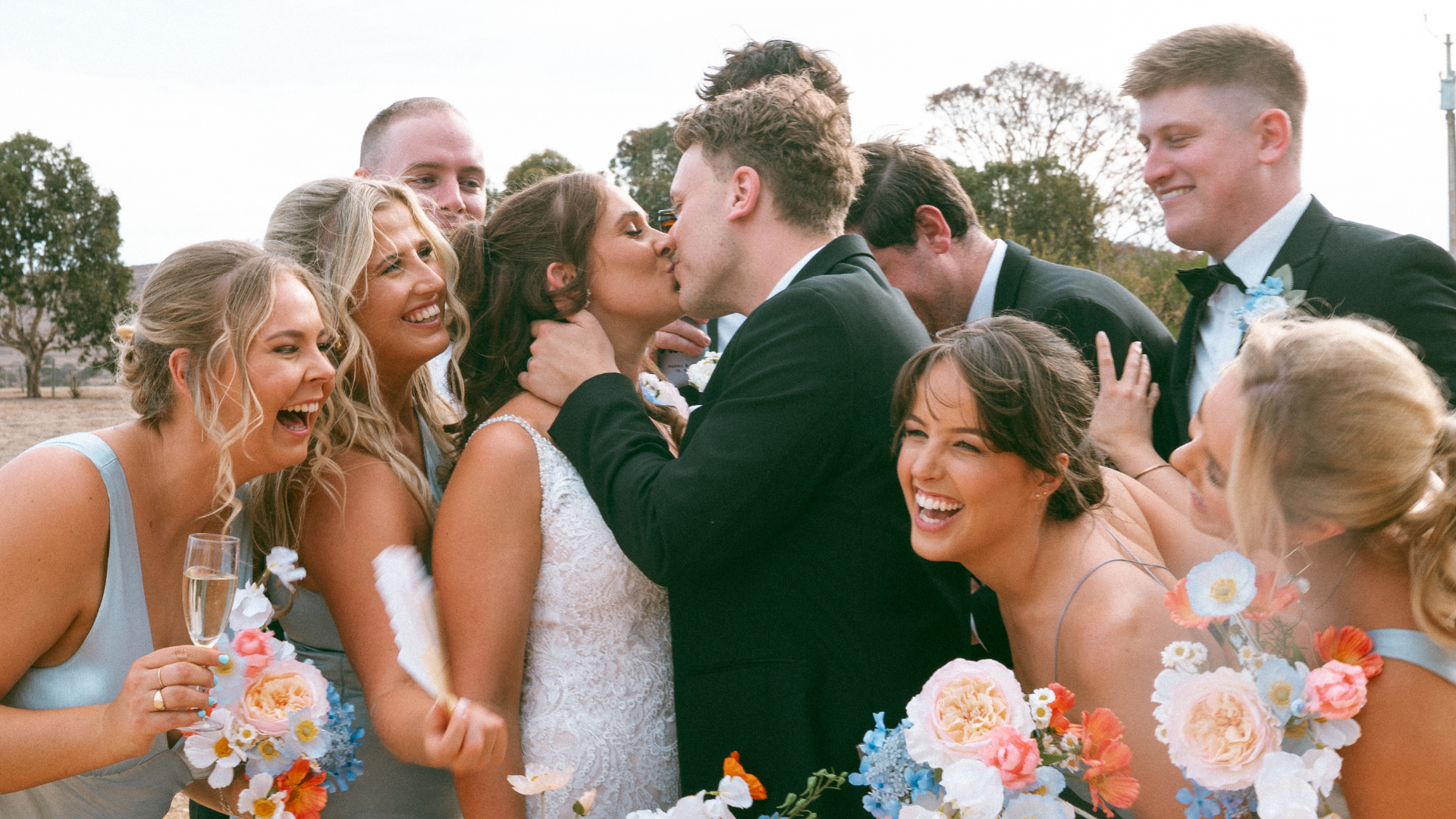 man and woman wedding couple kiss as their bridal party cuddle and cheer port Lincoln eyre peninsula