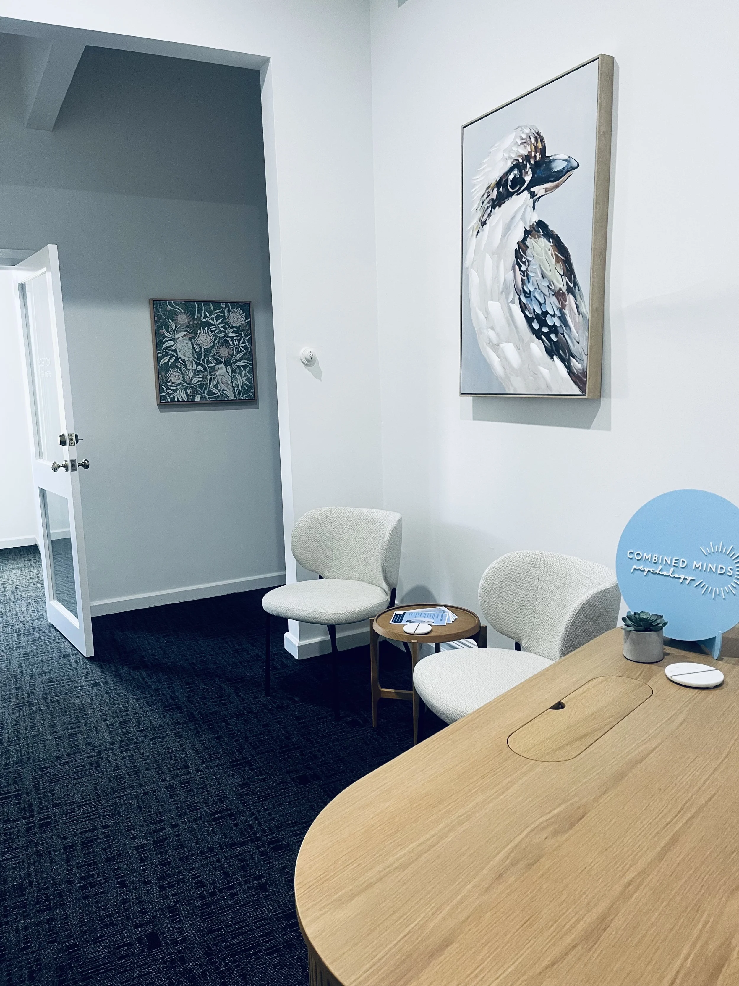 Reception / waiting room at Combined Minds Psychology in South Perth including seating and wall art featuring kookaburras, creating a warm, relaxed, comfortable environment