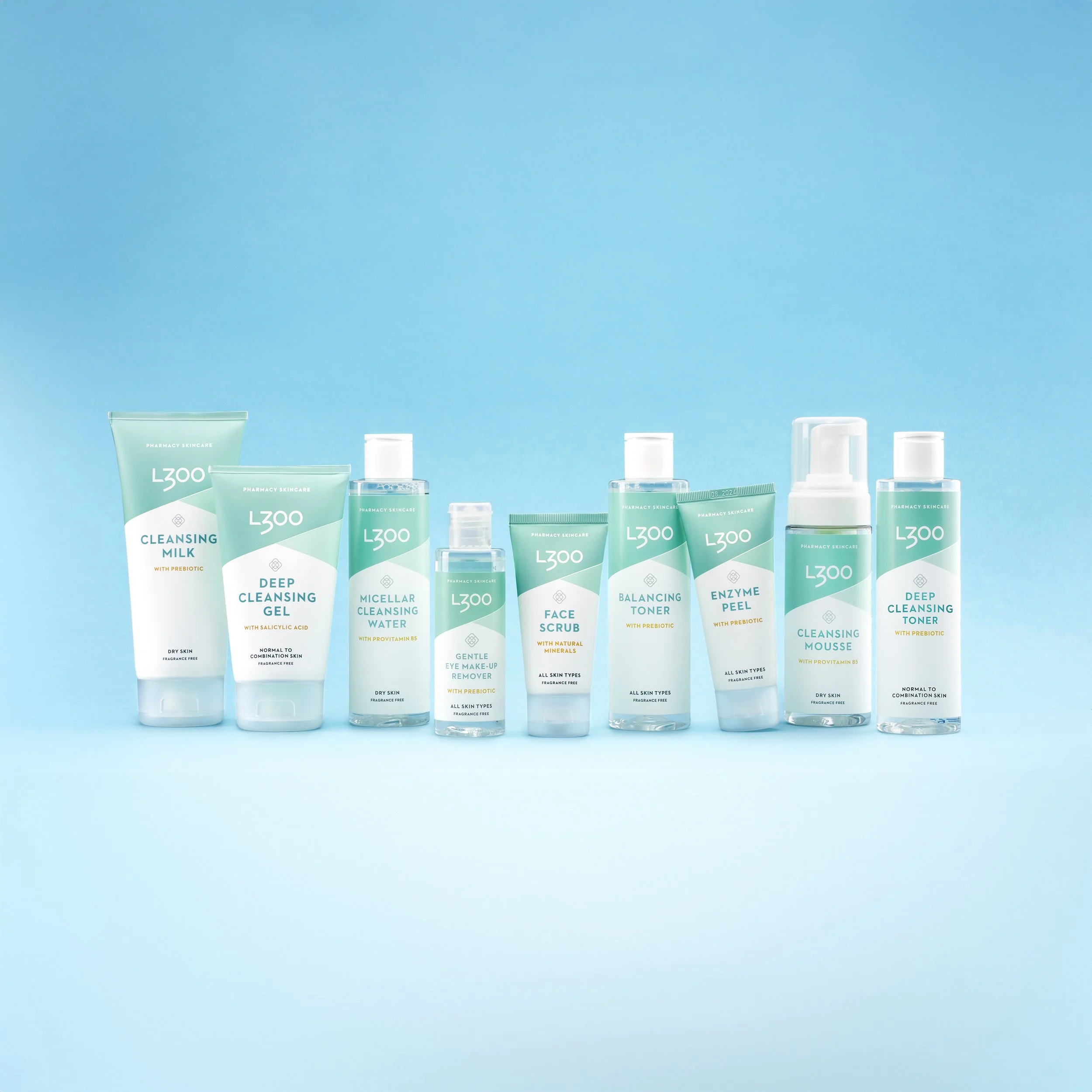 Collection of skincare products including cleansers, toner, face scrub, and water on blue background.