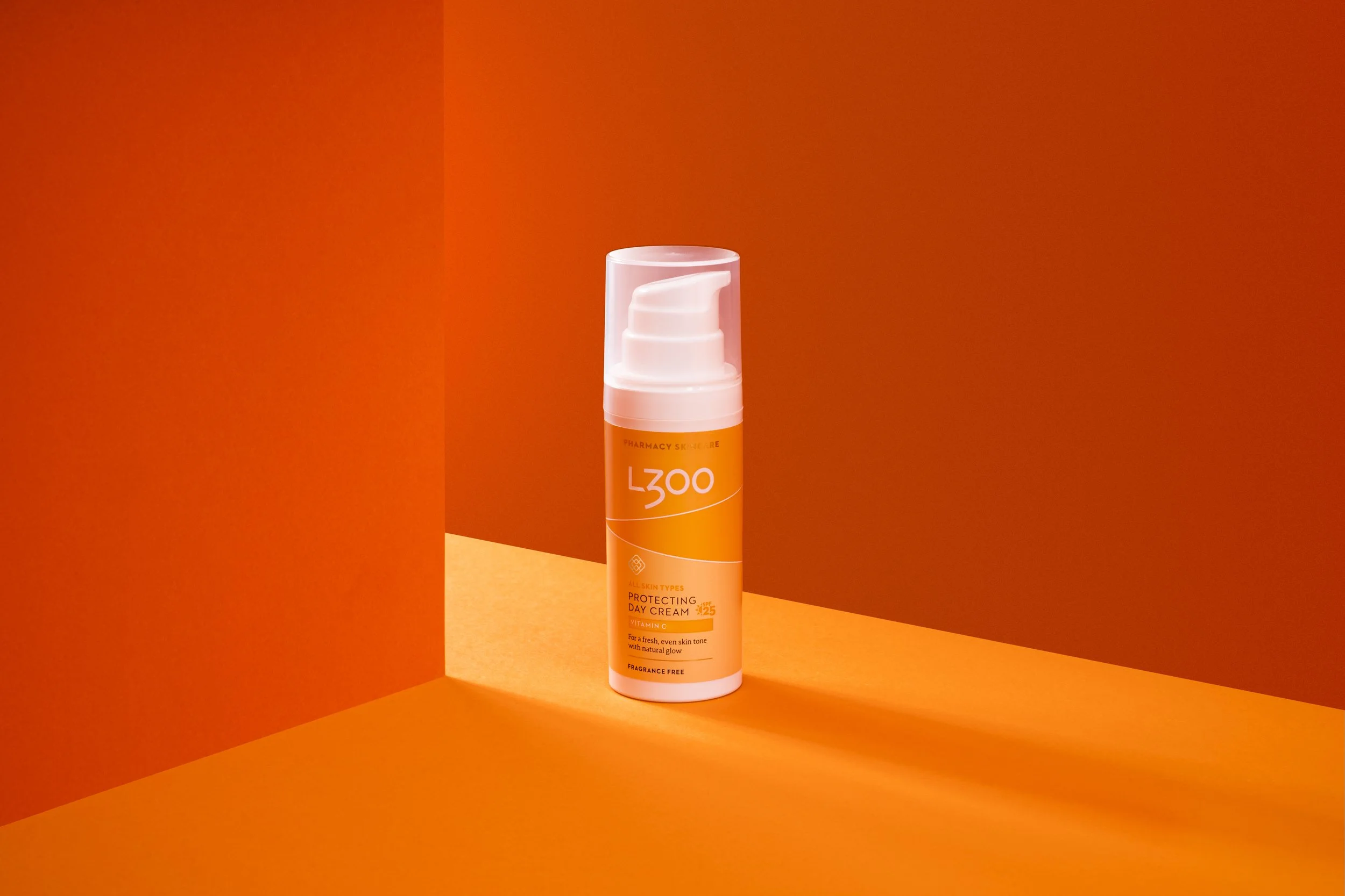Orange bottle of L300 Protecting Day Cream with SPF 25 on an orange background.